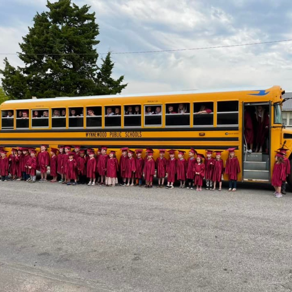 bus with students in graduation gear 