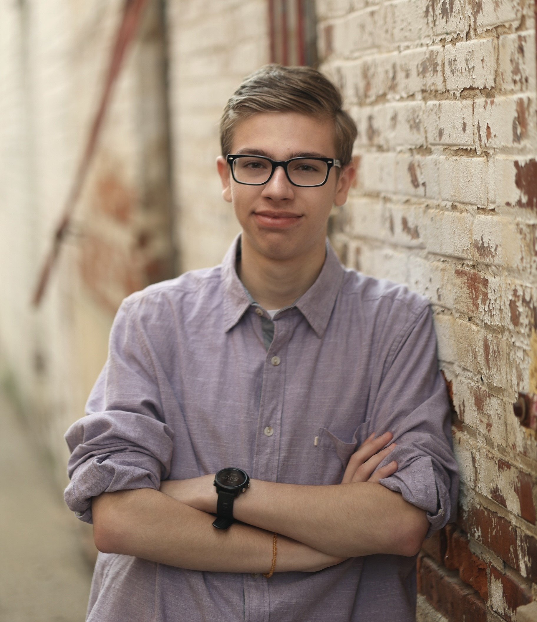 senior luke standing next to brick wall