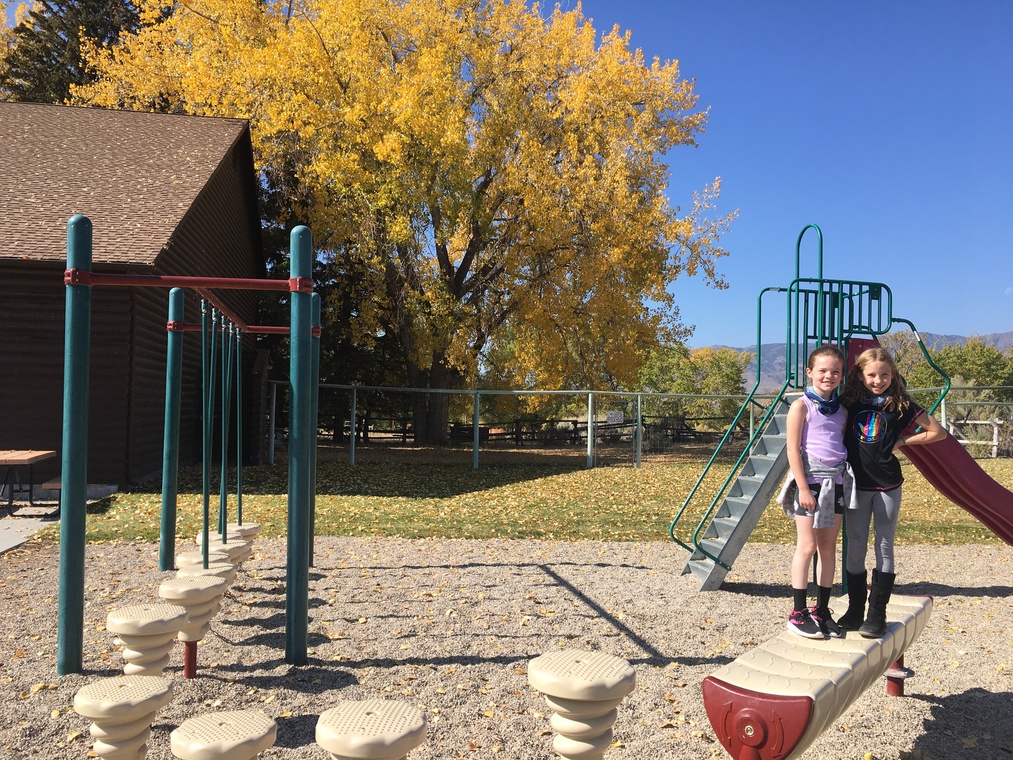 Two students on the playground outside Wapiti Elementary