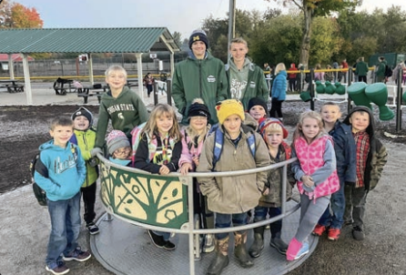 This is a group of students that are various ages smiling and looking at the camera. 