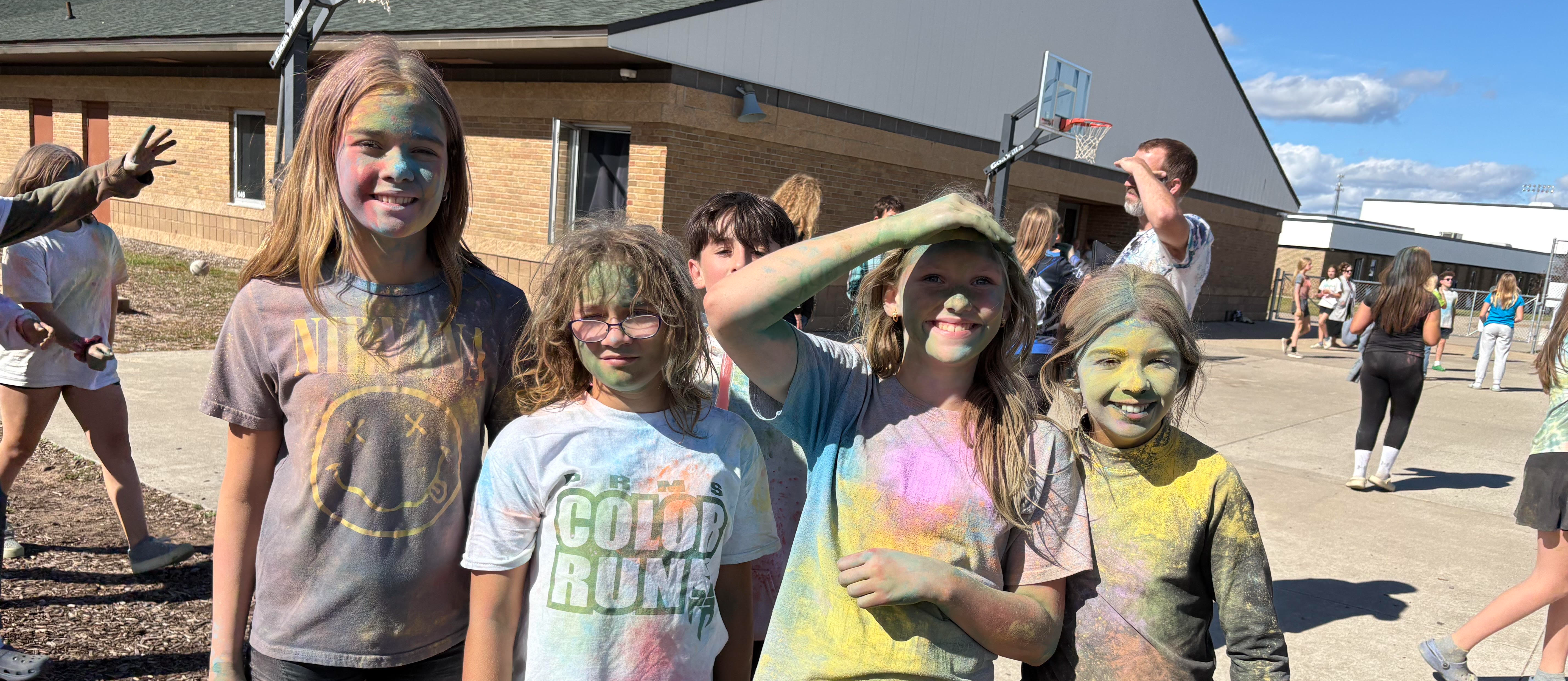 Three students covered in colors