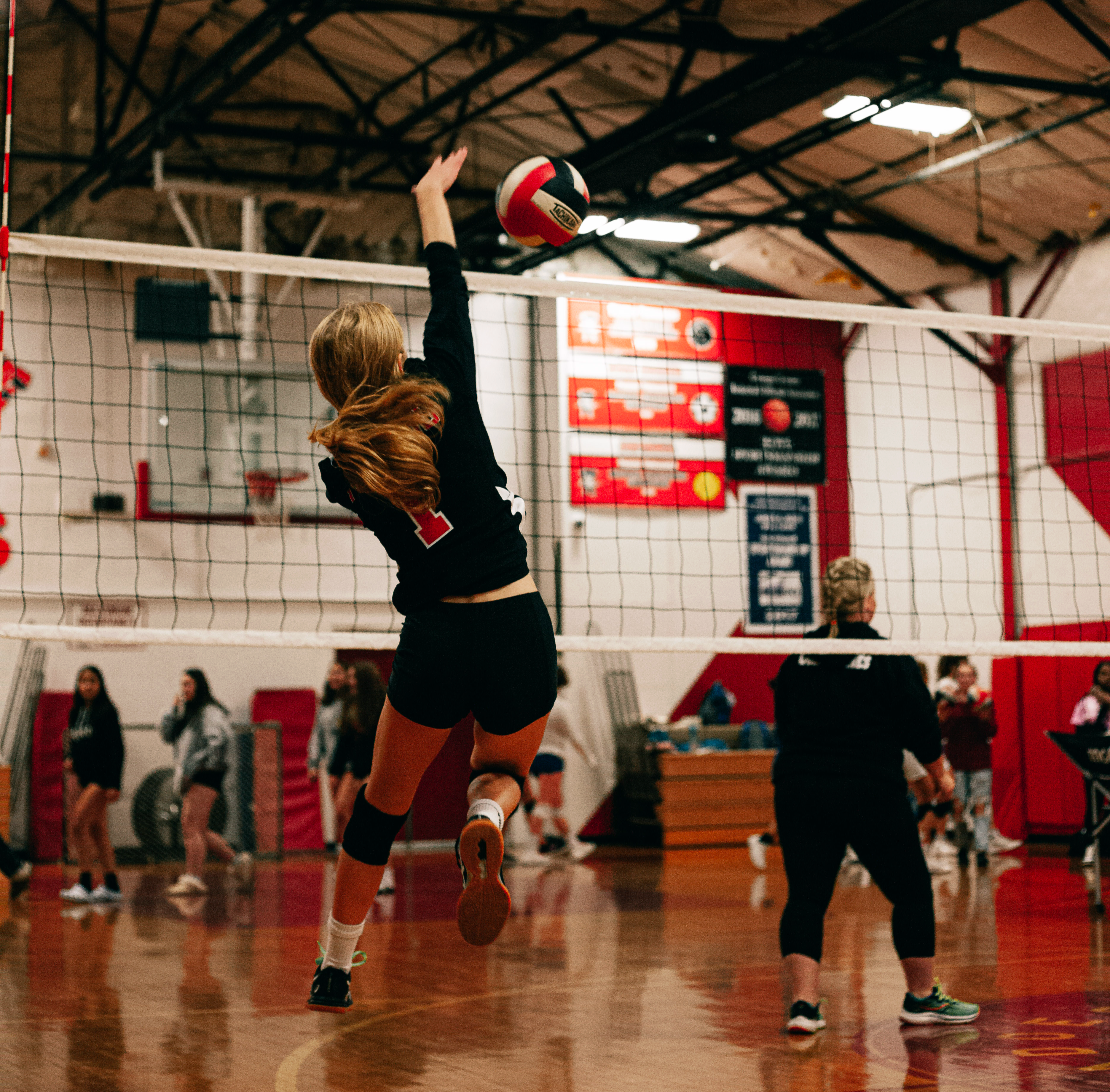 Volleyball player hitting ball over the net