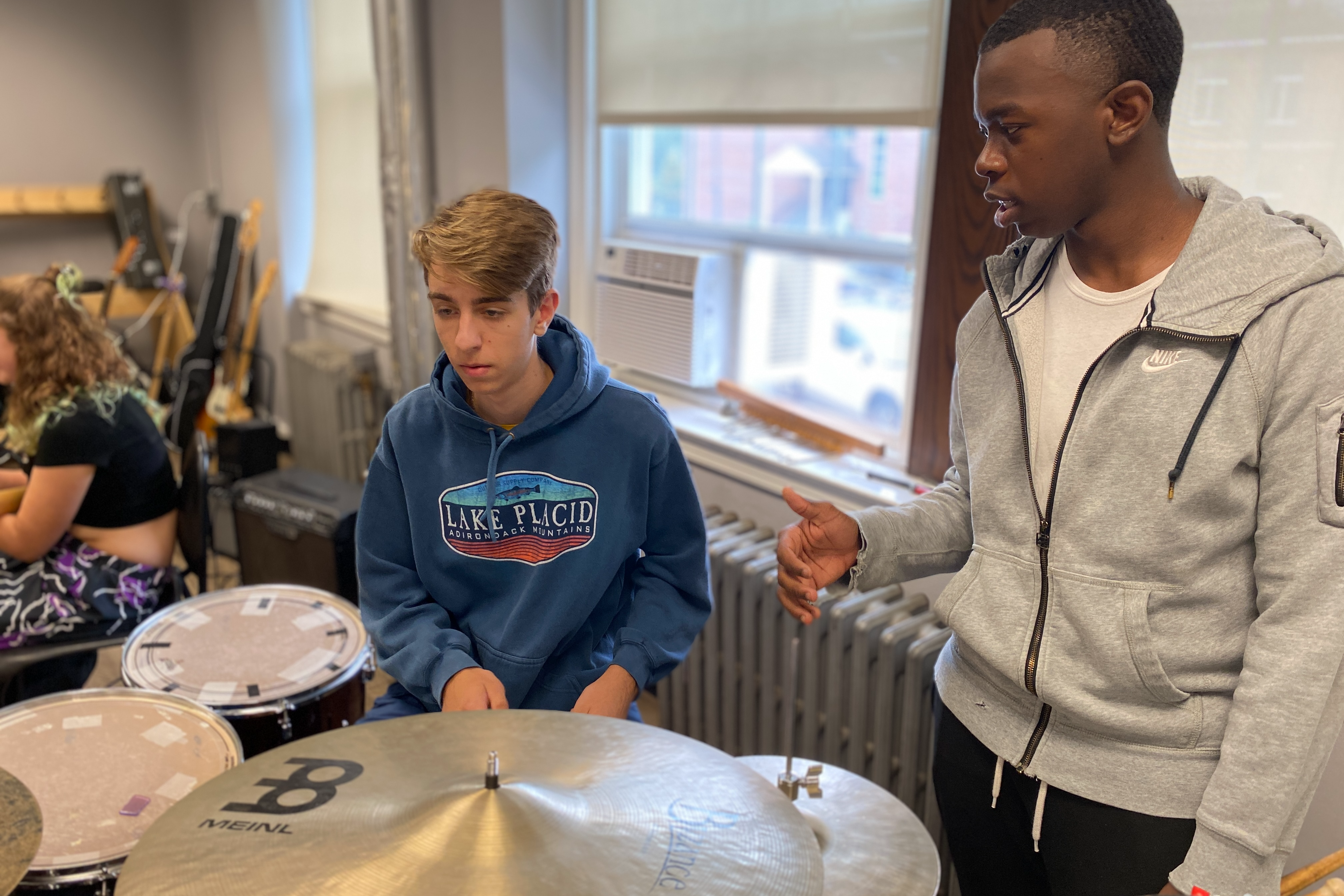 Two students at drum set in orchestra class