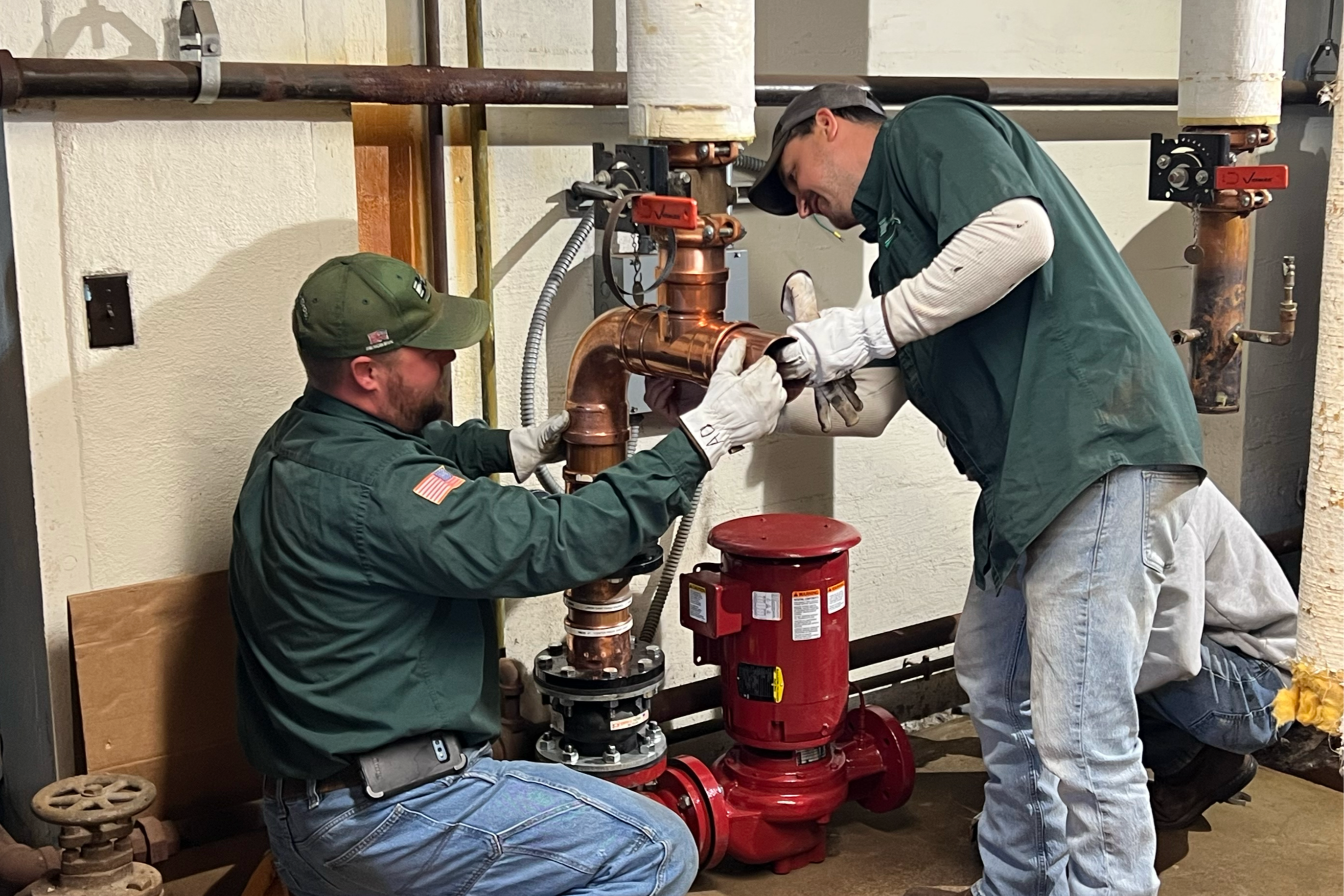 Workers installing new boiler pumps