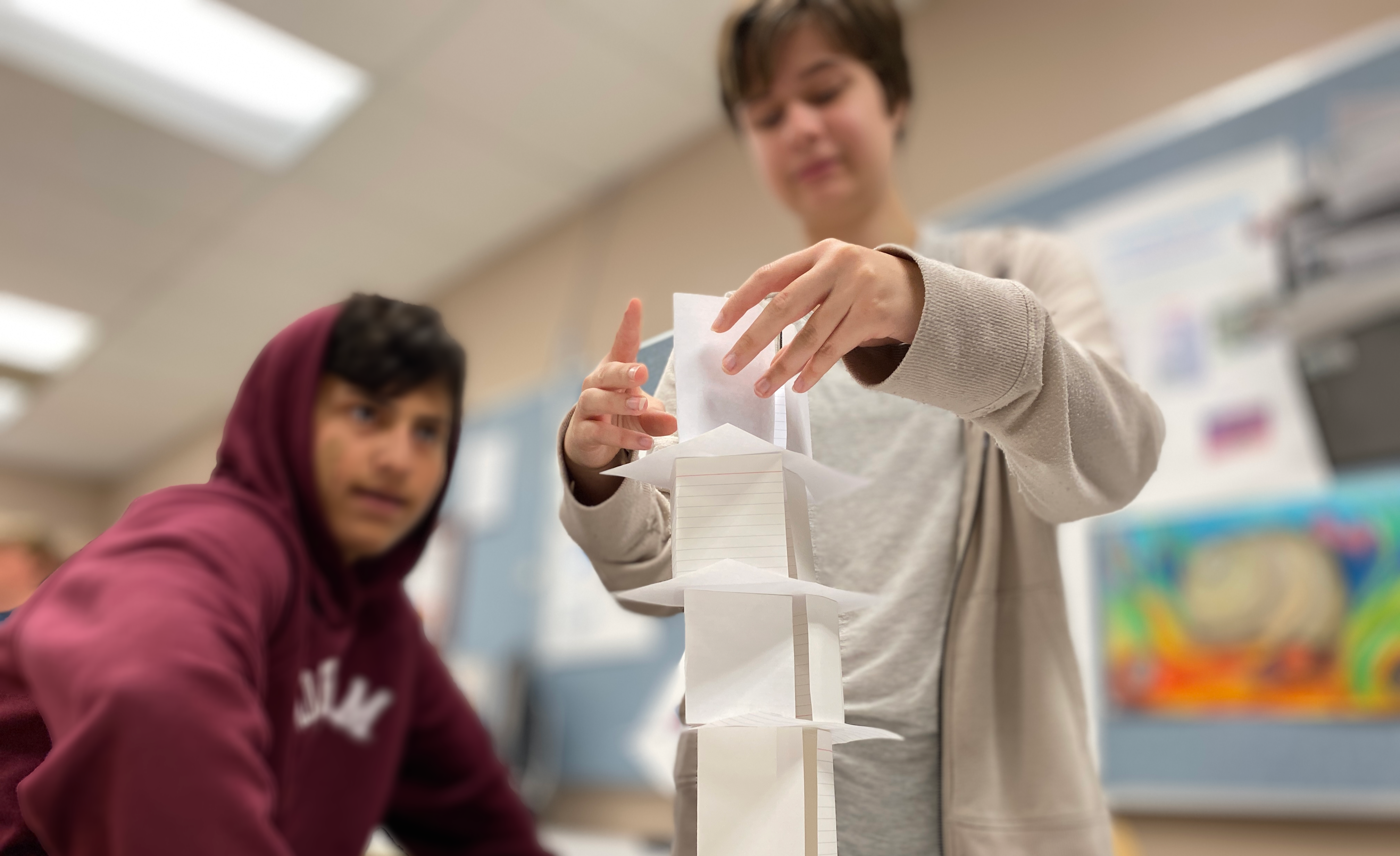 Students working on STEM project, stacking papers