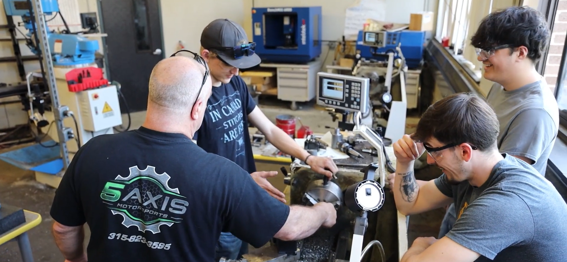 Advanced Manufacturing students and teacher around machinery in class