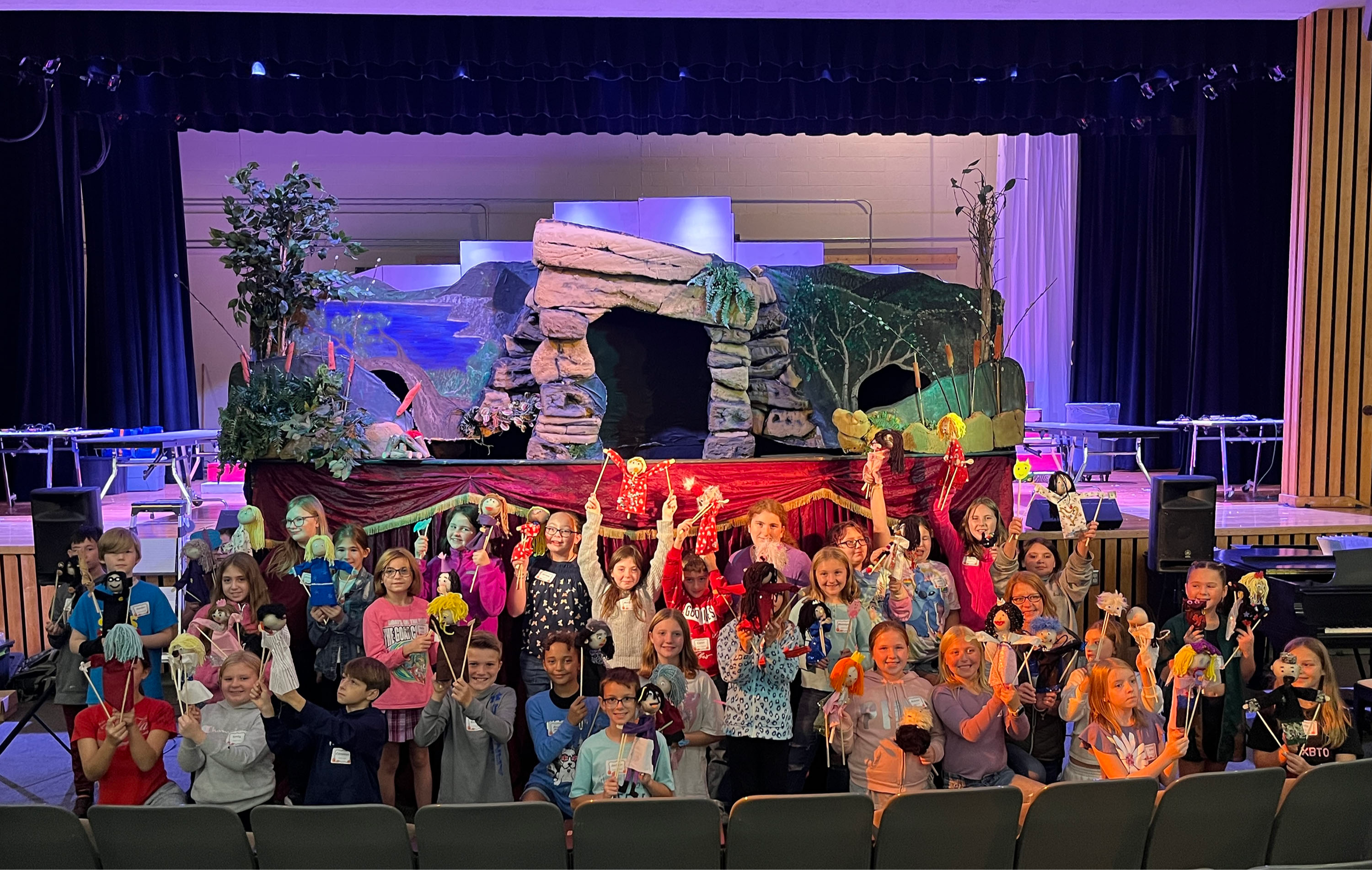 Honors Program students pose with puppets in front of stage