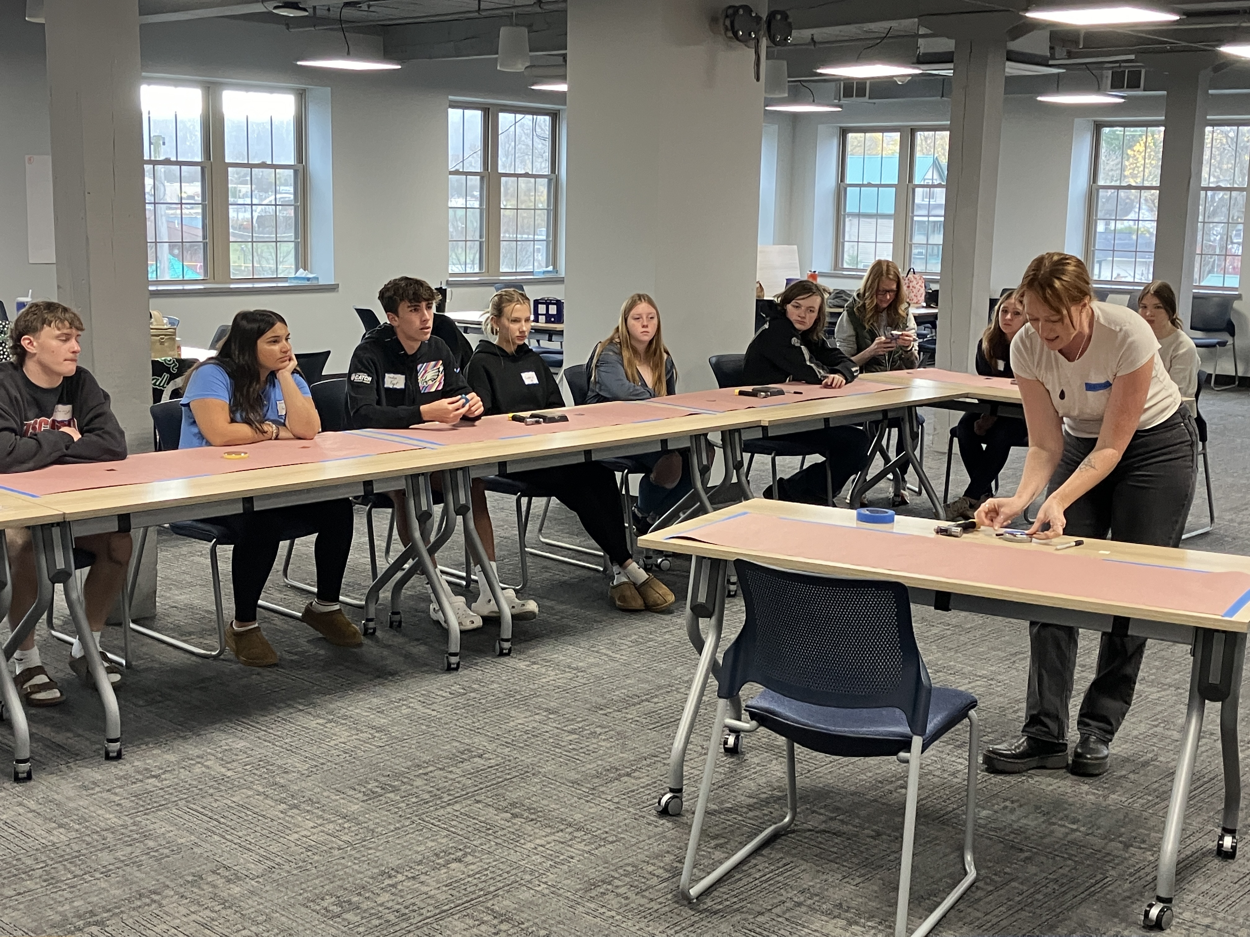 Students at long table with metalsmithing artist presenting in front of them