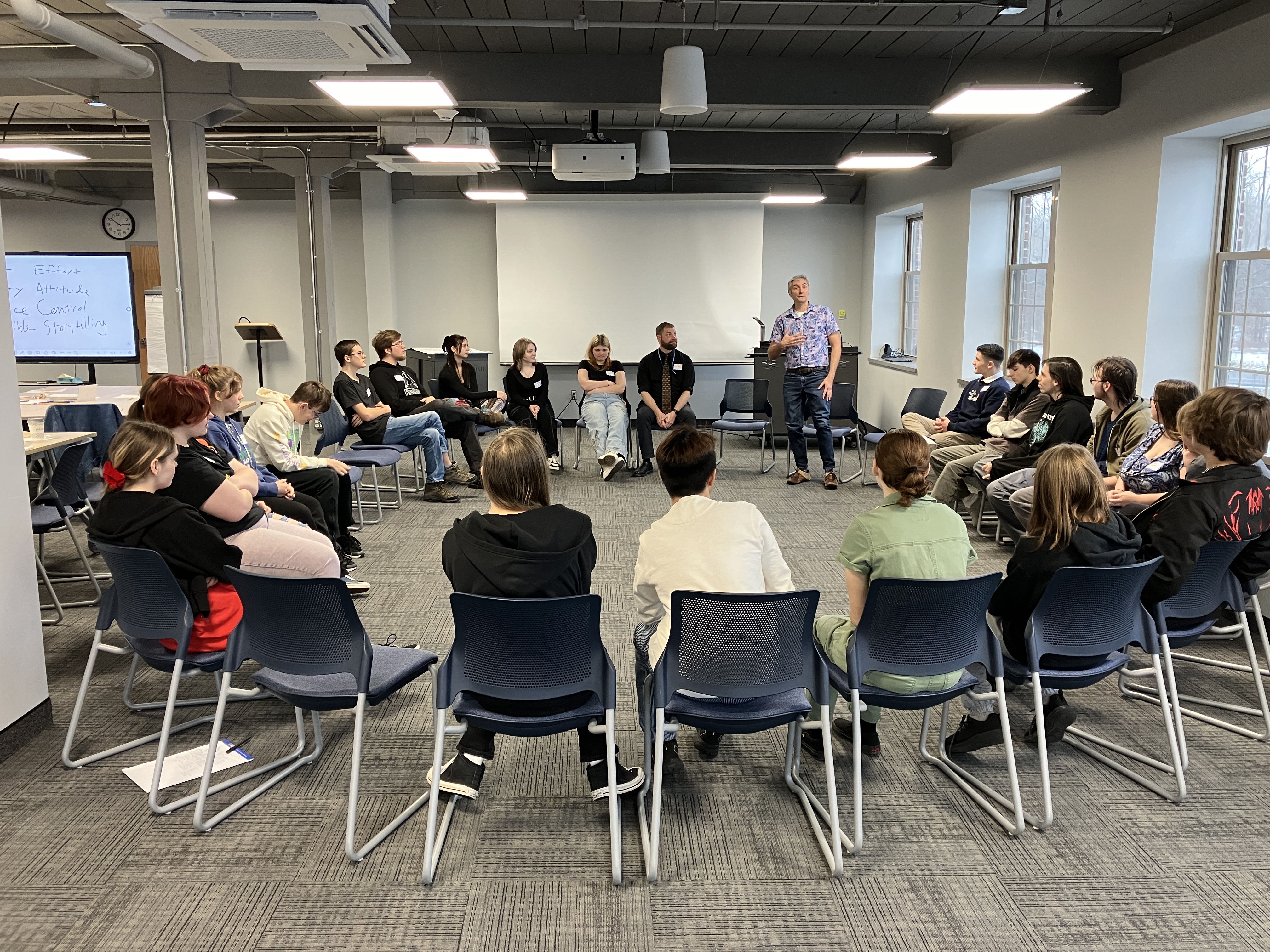 Students sitting in a circle with Matthew Powers standing at workshop