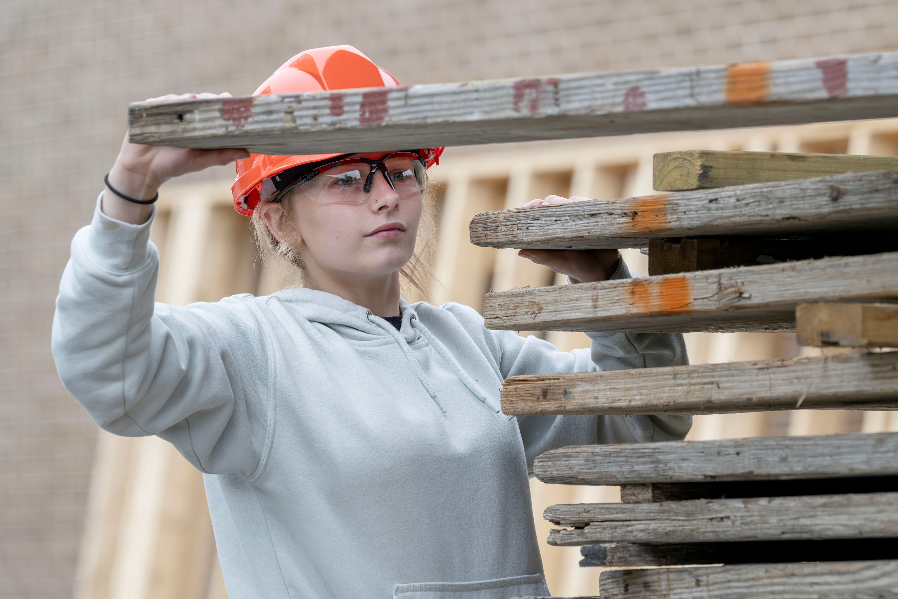 Building Construction student grabbing a piece of wood