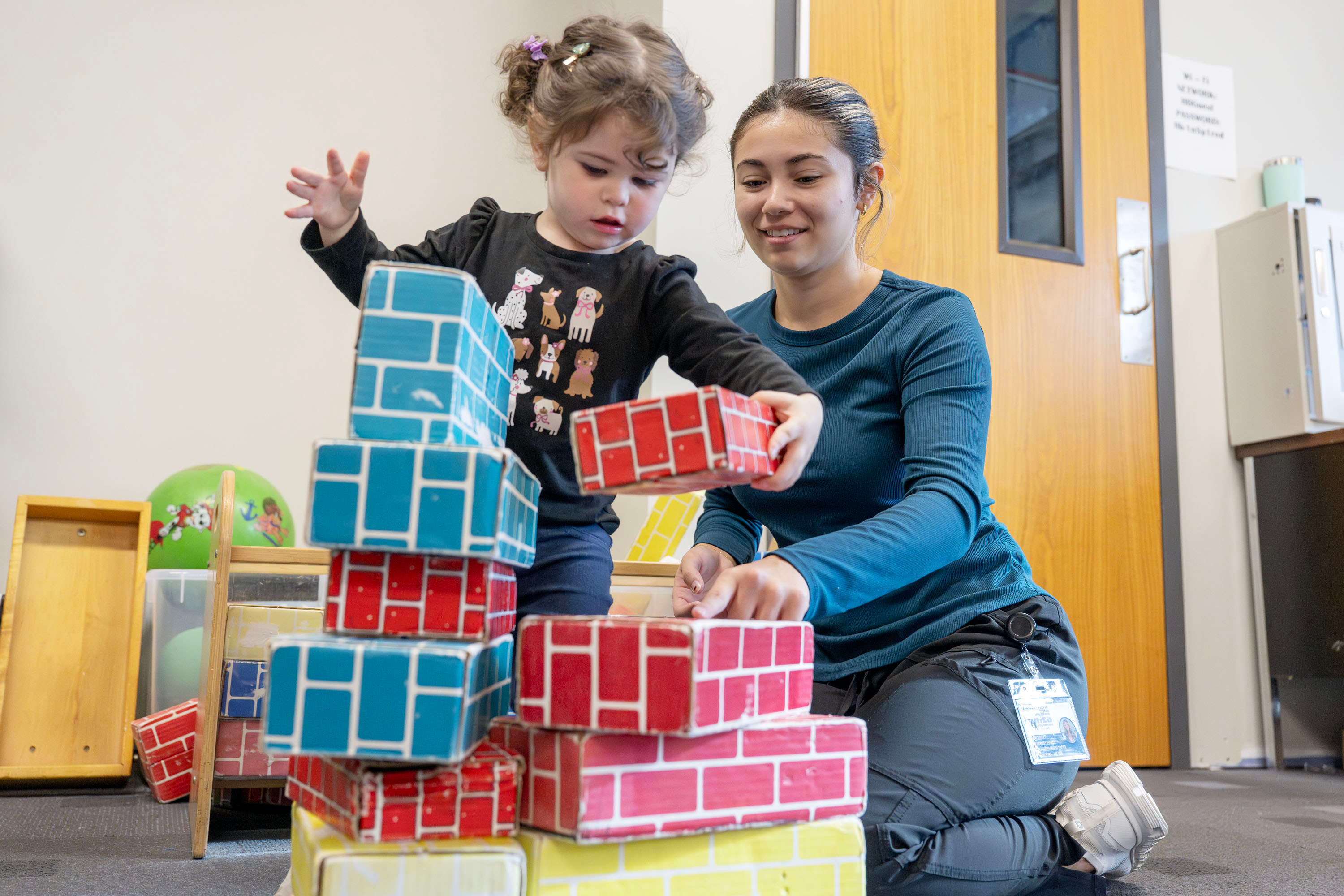 Child and Family Services student playing blocks with a young child during class