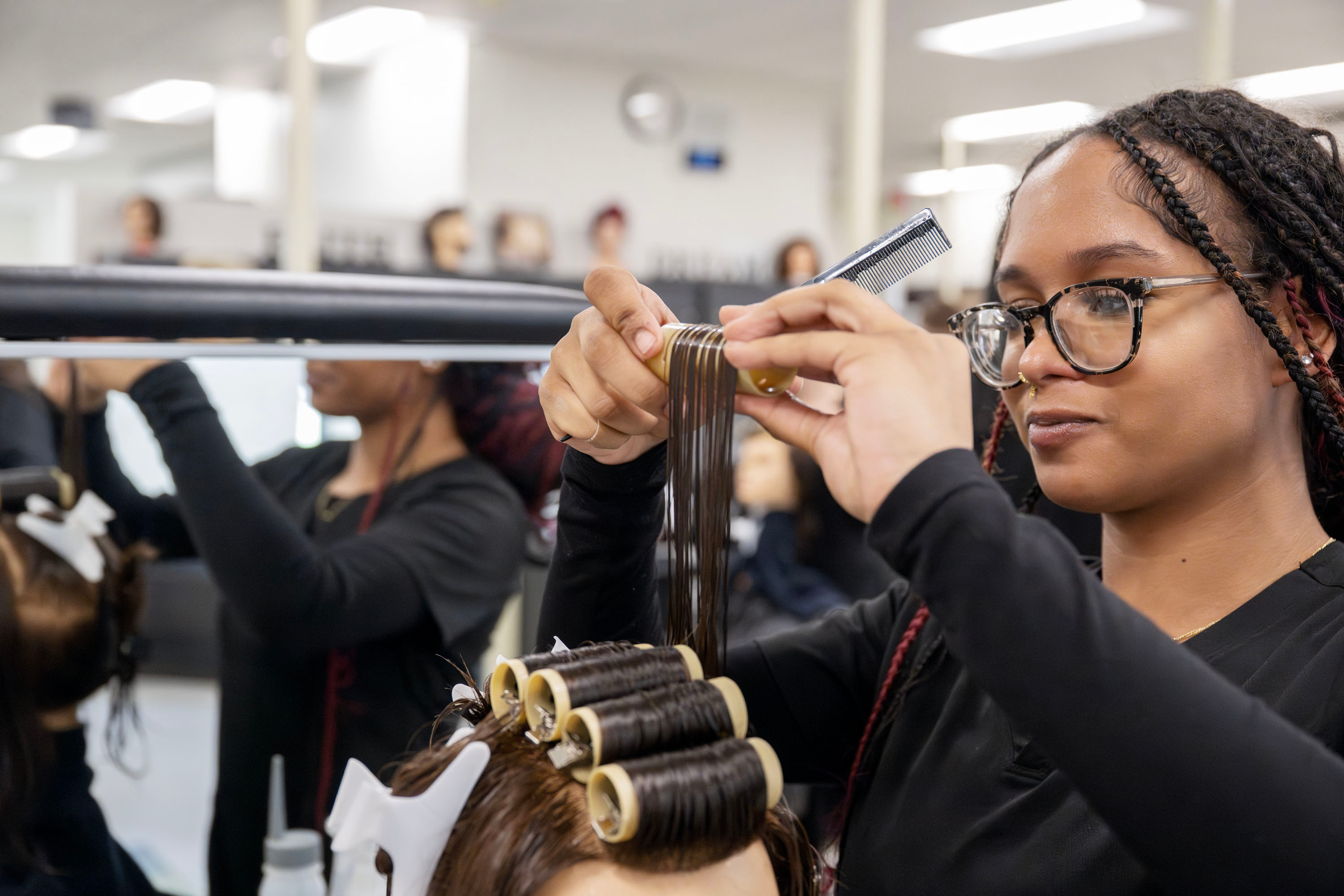 Cosmetology student doing the hair of a mannequin