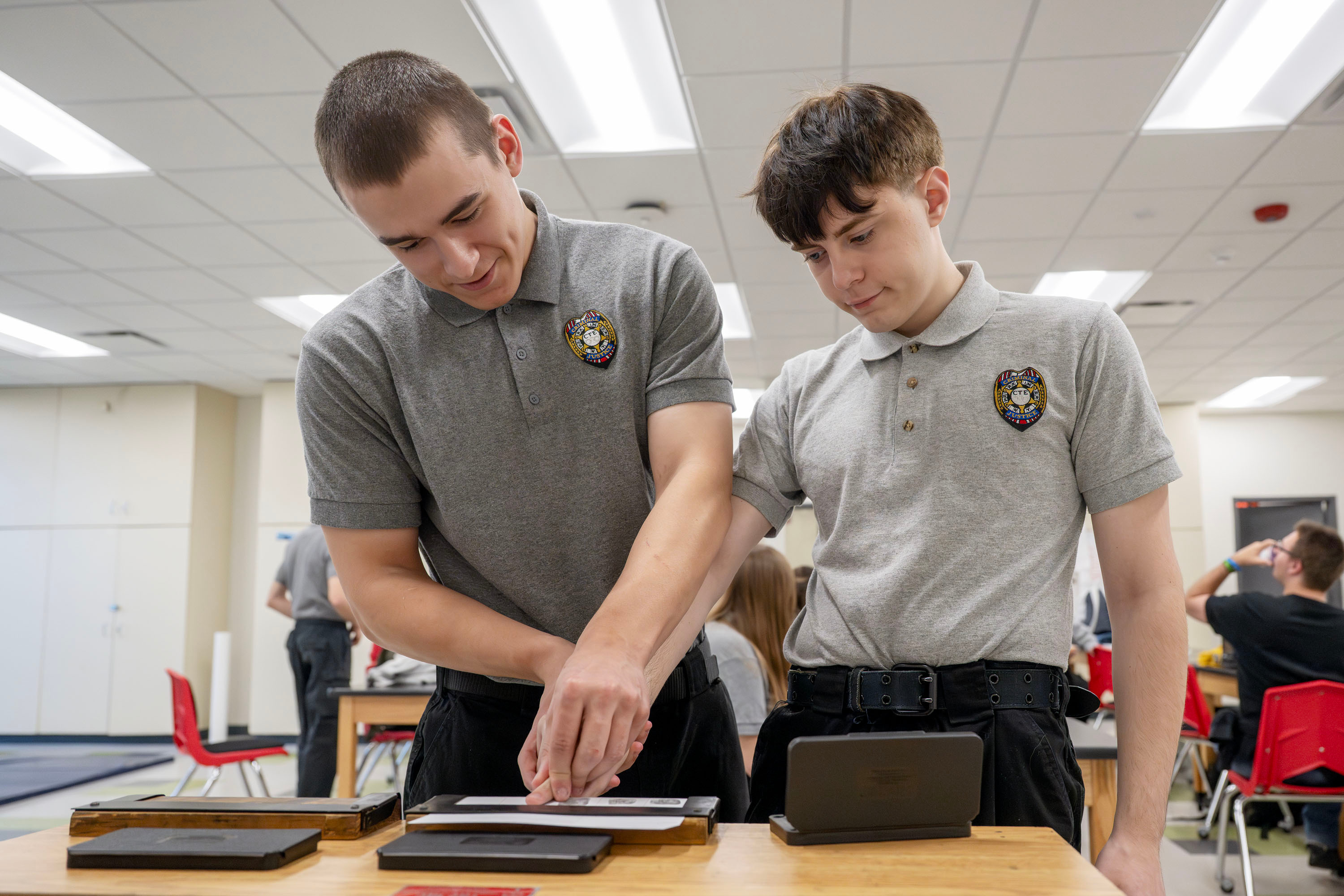Two criminal justice students practicing fingerprinting