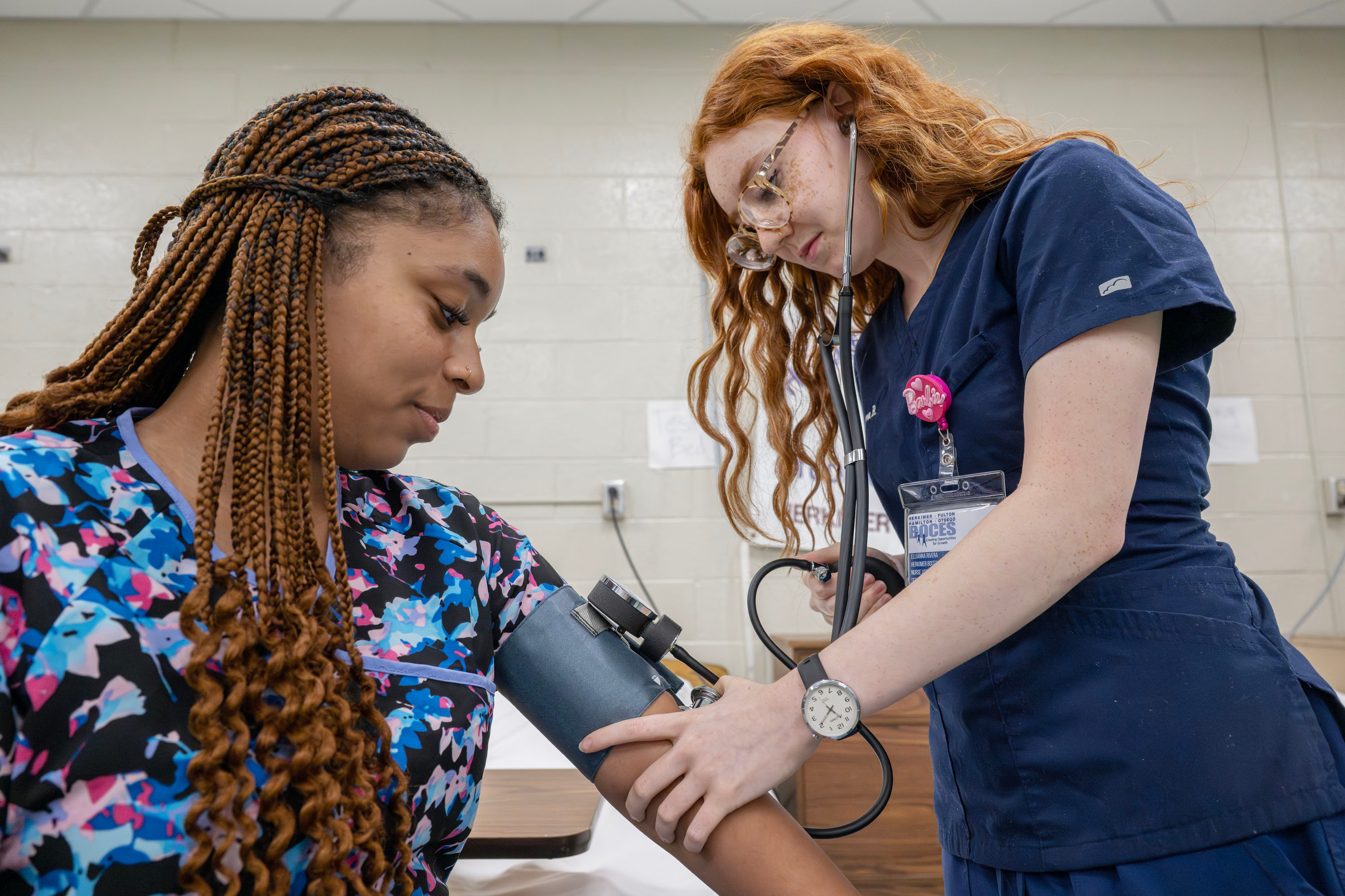 Two Health Science Careers students - one is taking the blood pressure of another