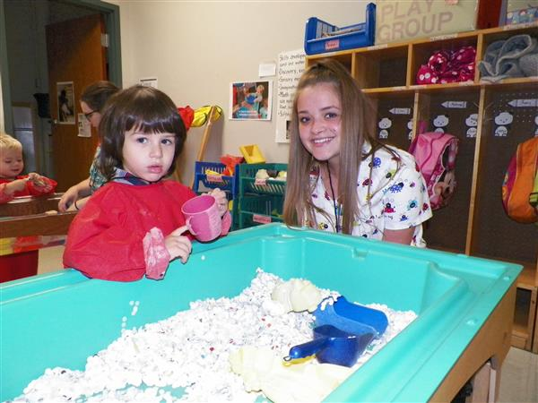 Child Family Services student with a preschool student playing at a table