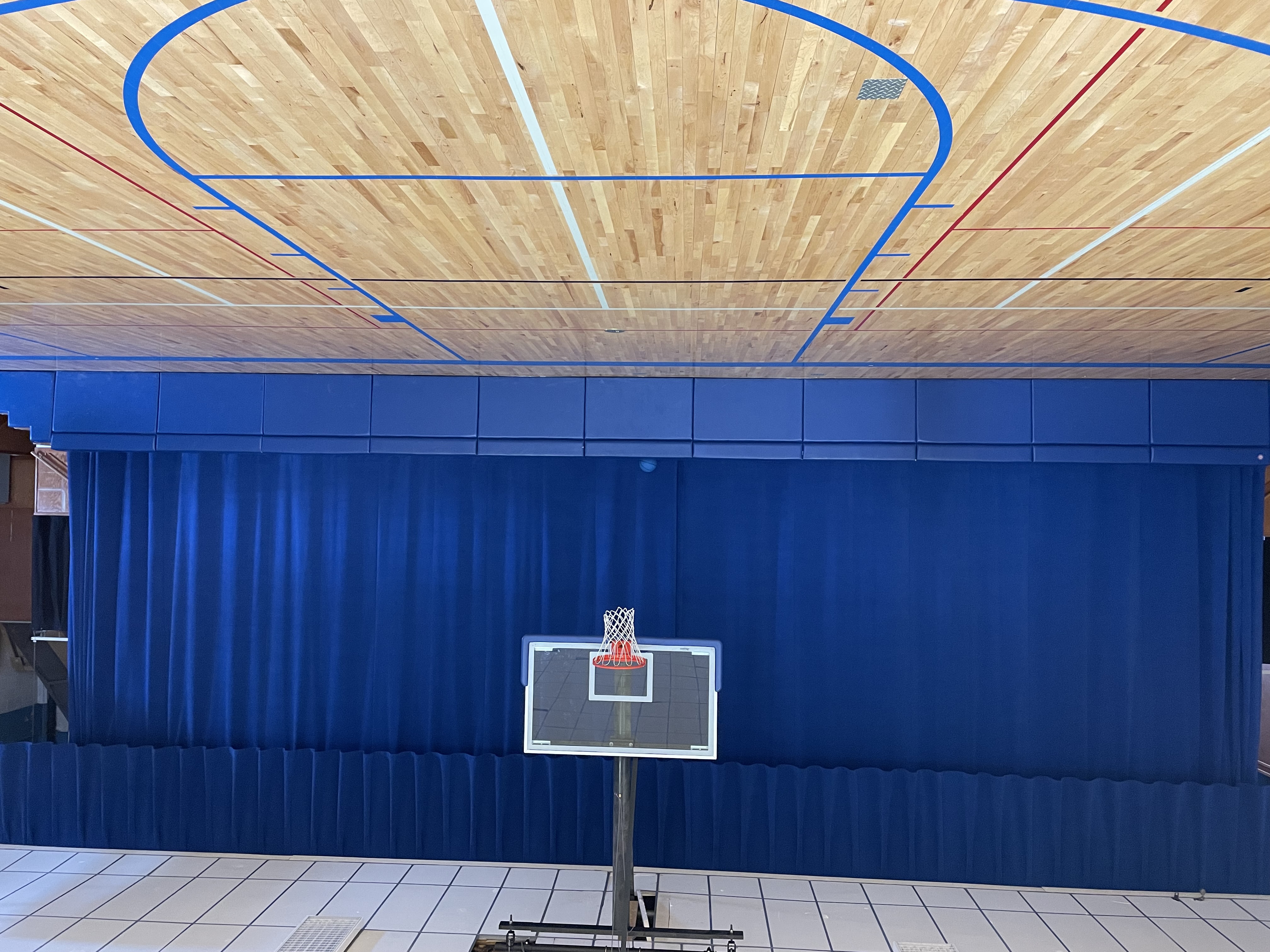 basketball hoop with blue stage curtains 