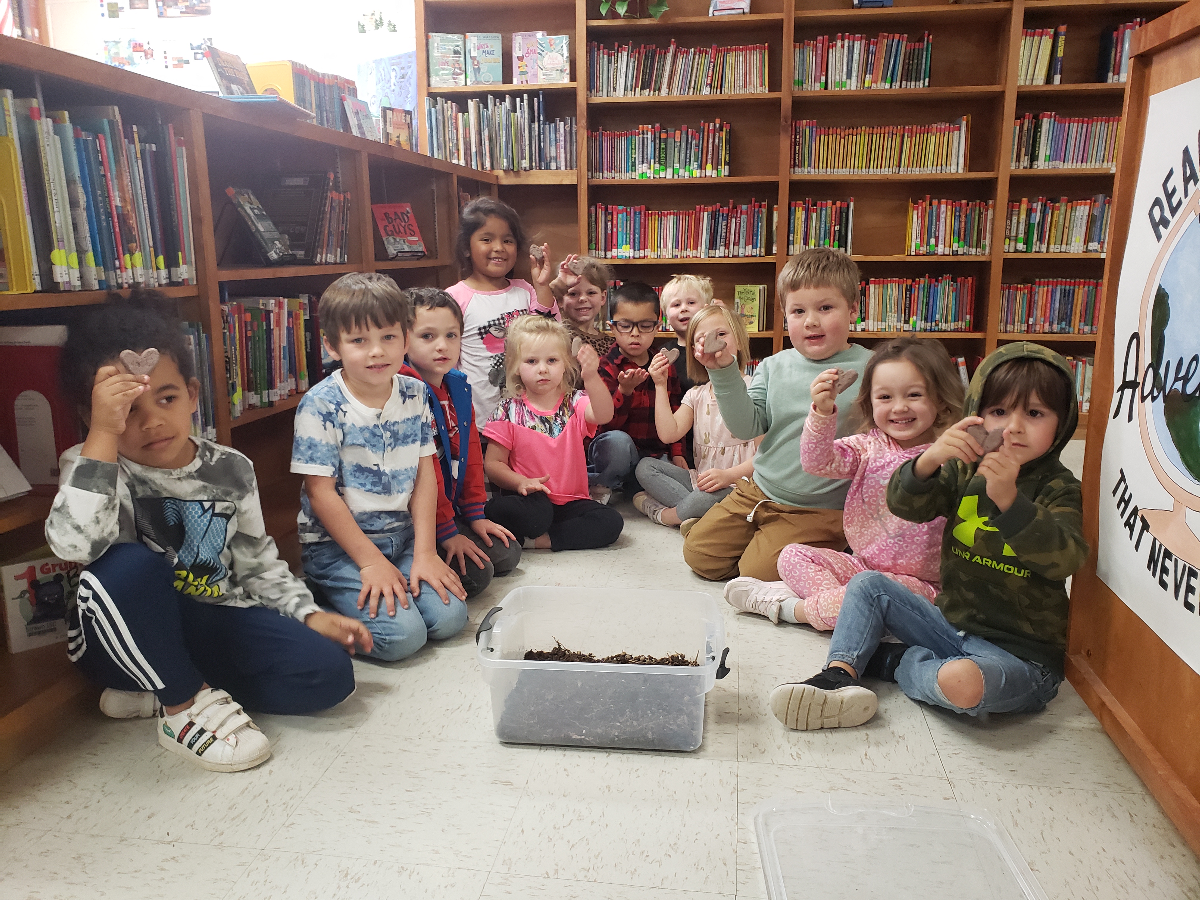 PreK class in library pose for a photo with their seed pods before planting