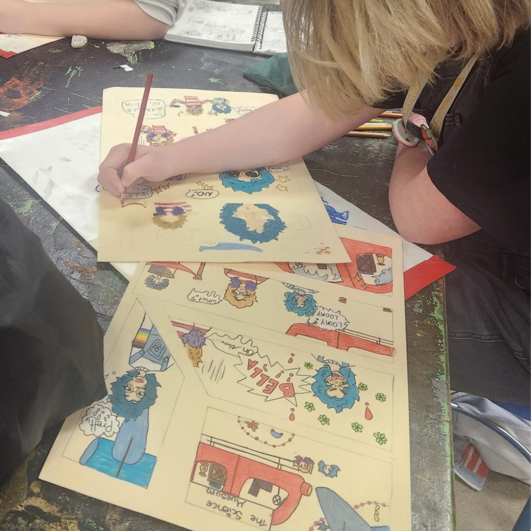 student working on creating a comic strip