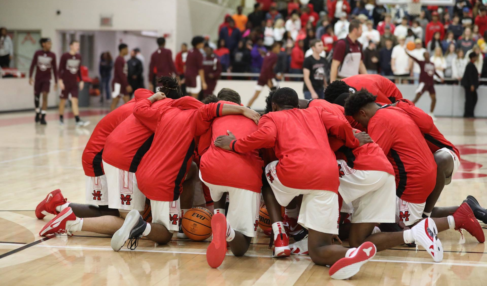 Basketball team huddled before a game. 