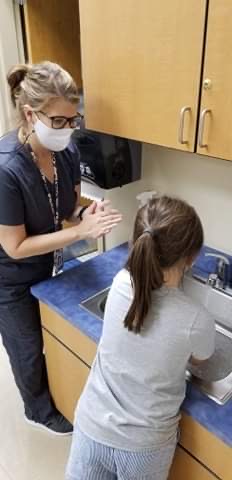Nurse with student washing hands