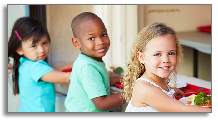 3 children with lunch trays smiling