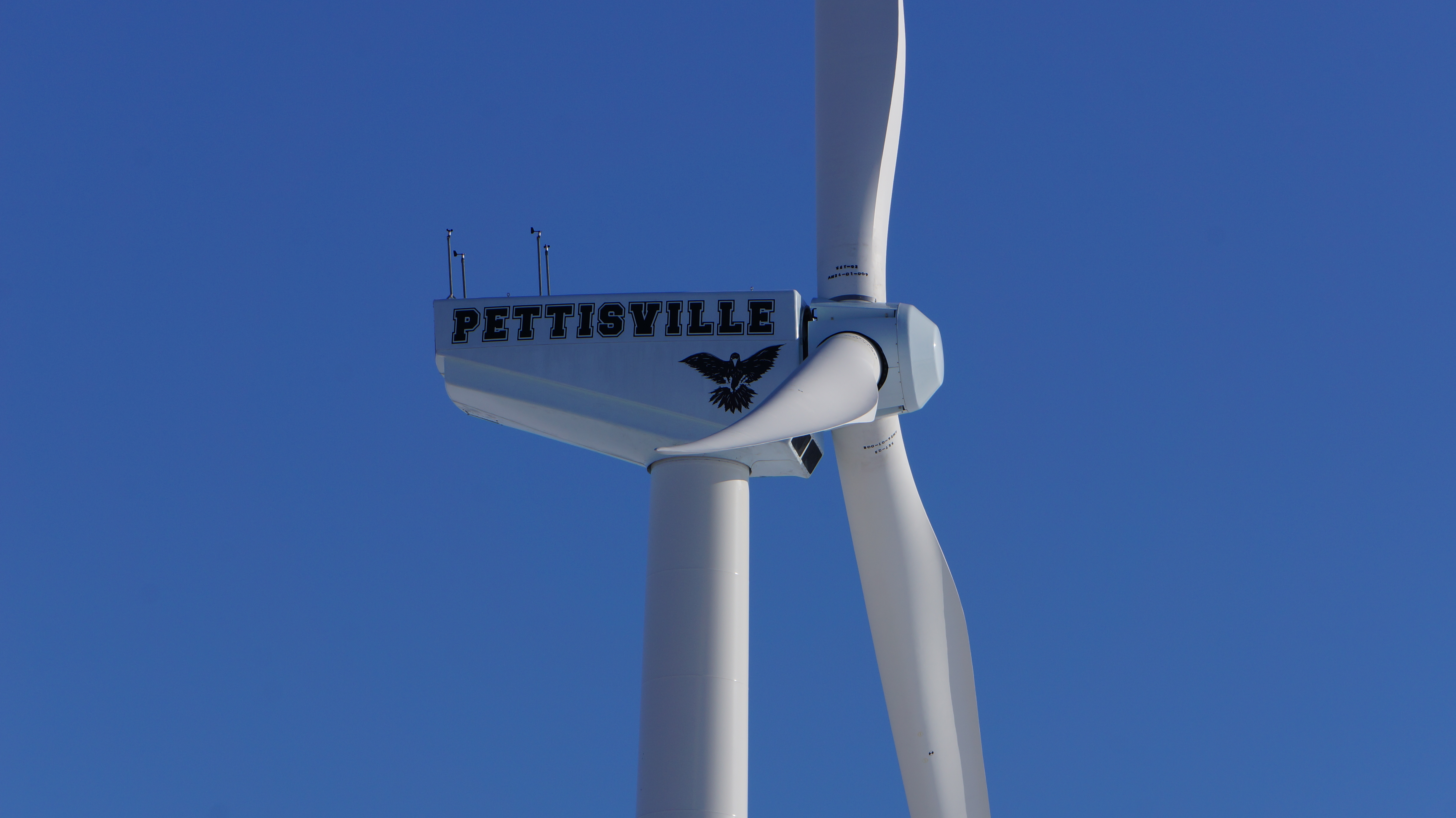 A picture of the side of the windmill that say's Pettisville and has the logo