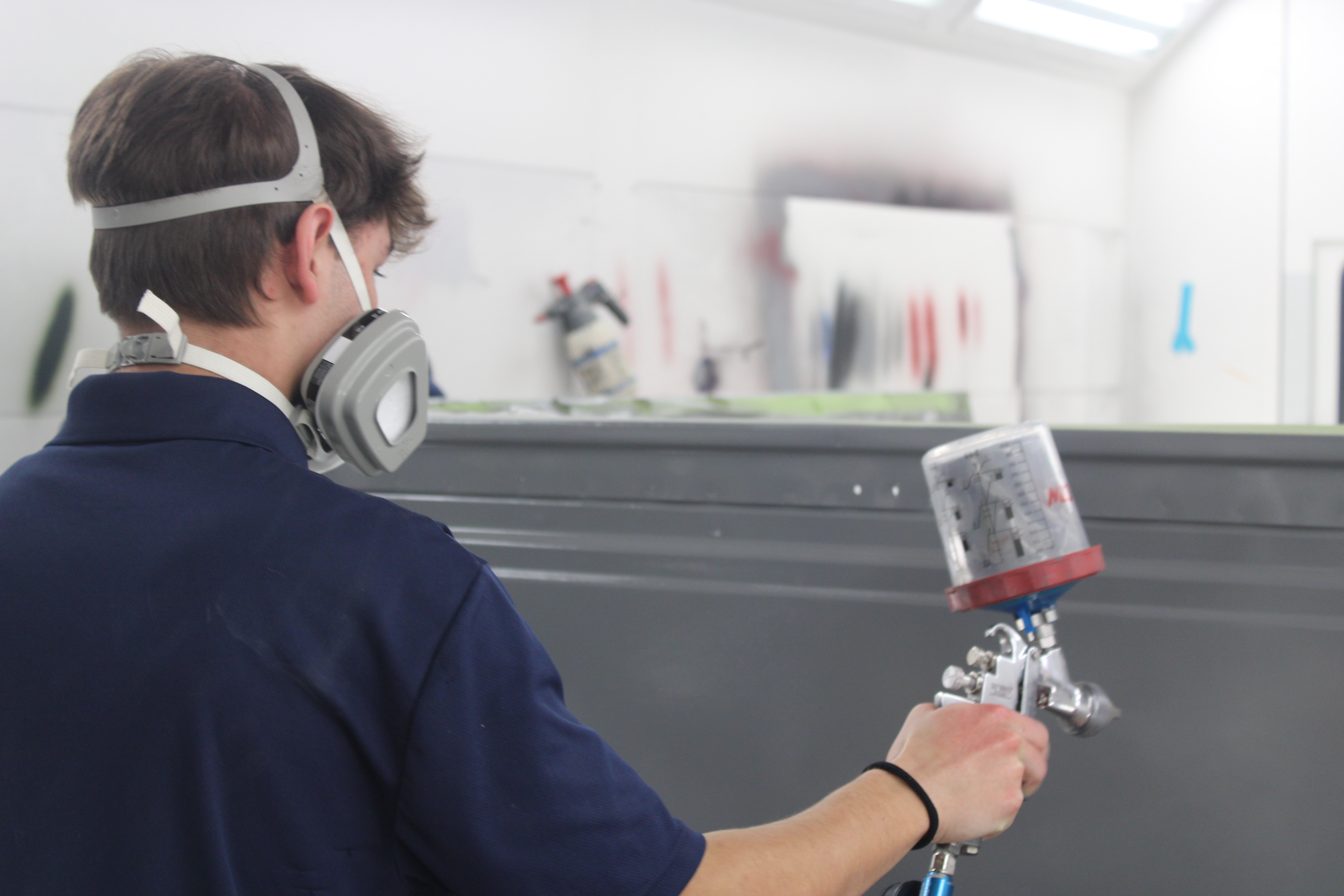 collision repair technology student in the paint bay