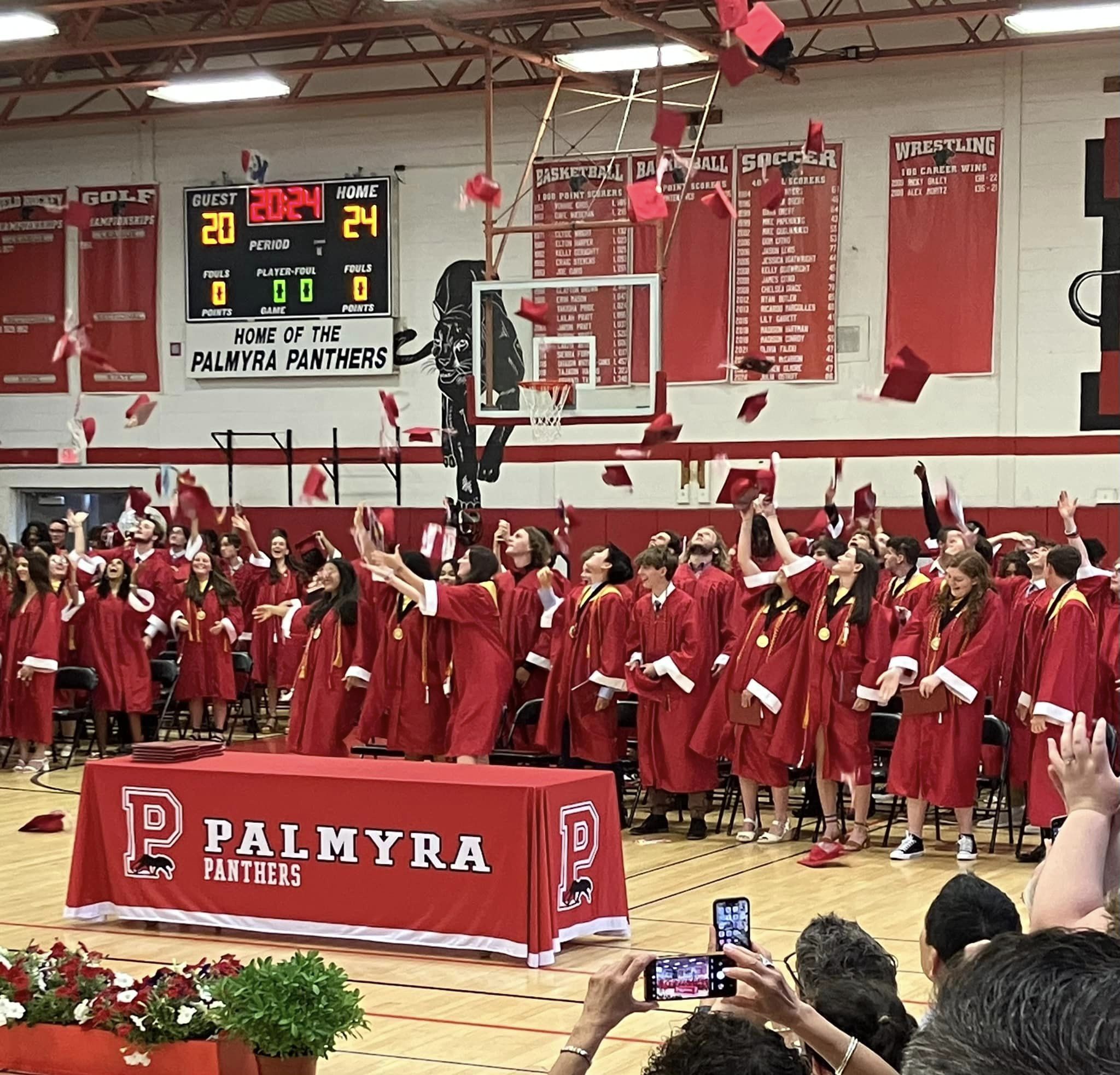 hats off to the class of 2024 tossing caps into air in gym