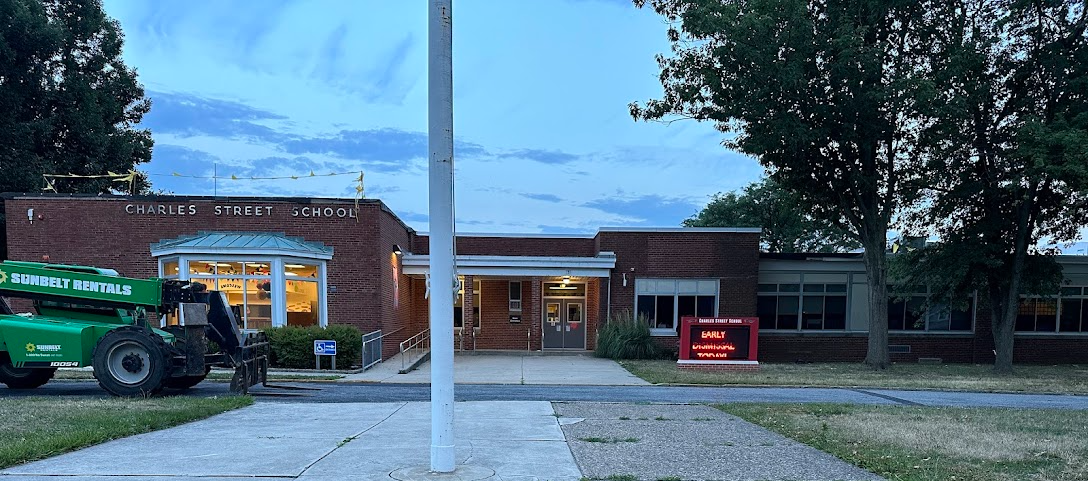 CSS front facade after sunset with equipment located in driveway for construction