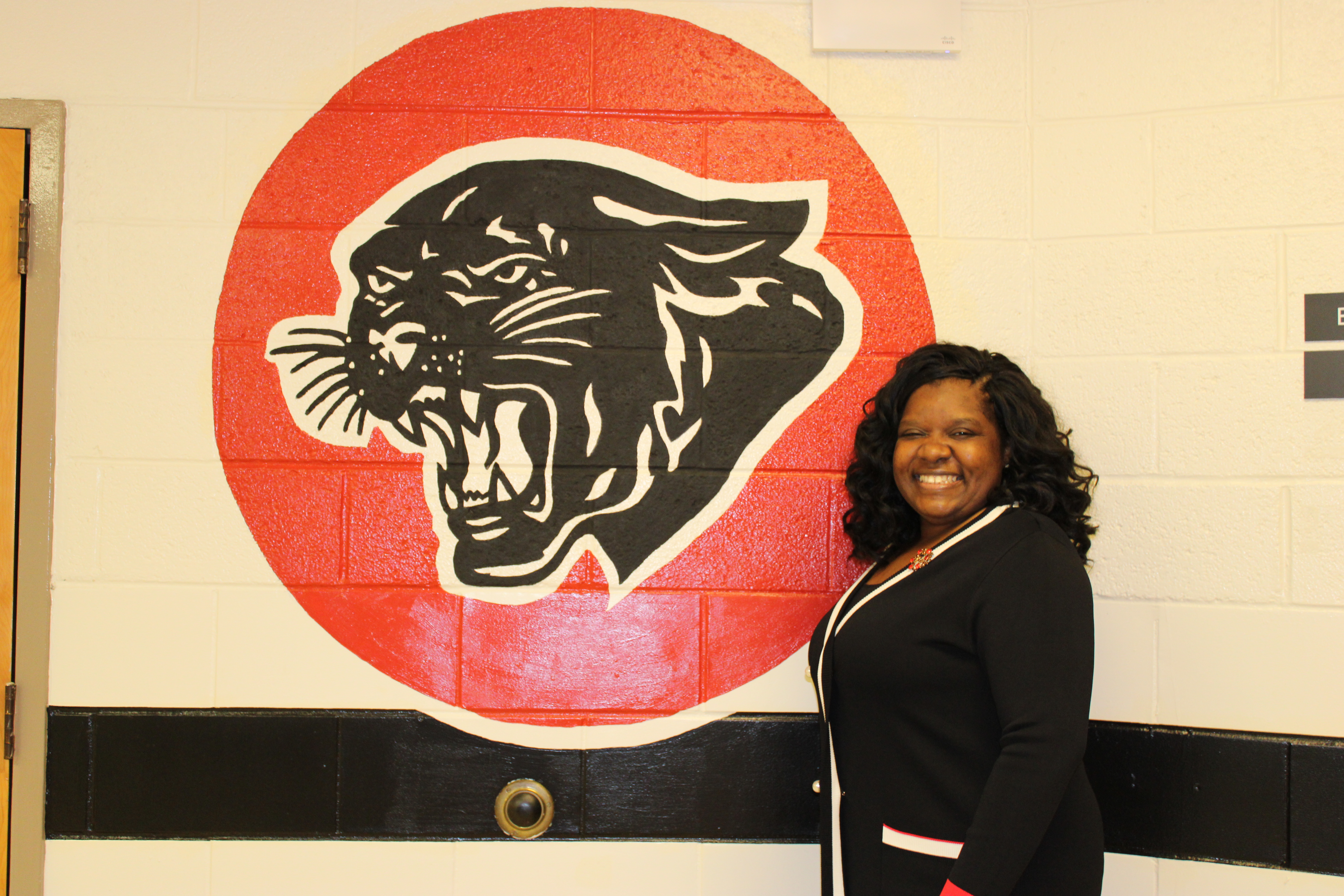 Principal Lee in front of the Panther Mural
