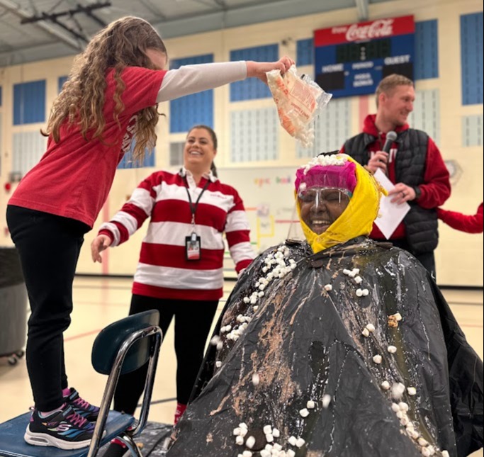 Principal Lee being covered with sundae ingredients