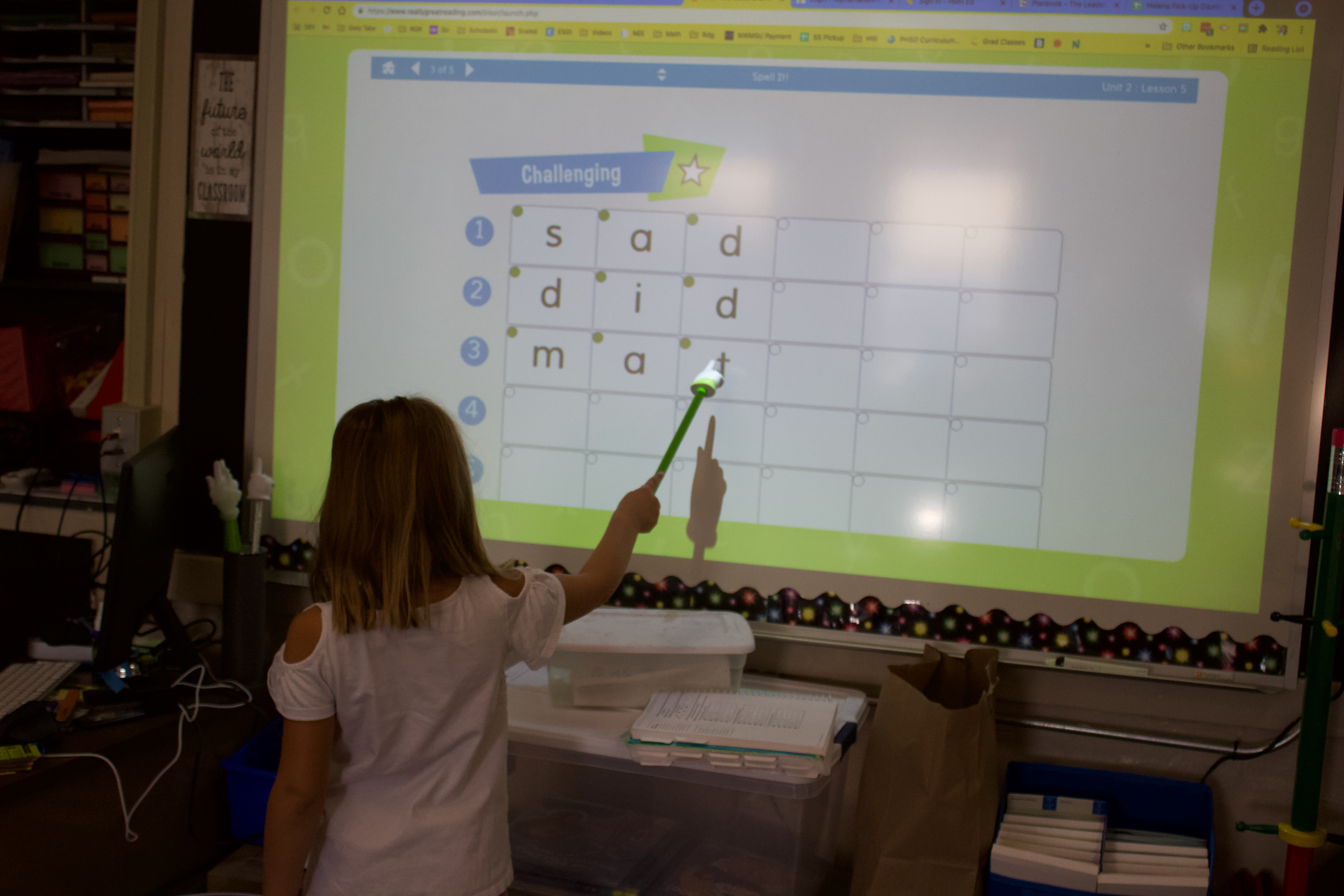 student points at letters in a word on the smart board