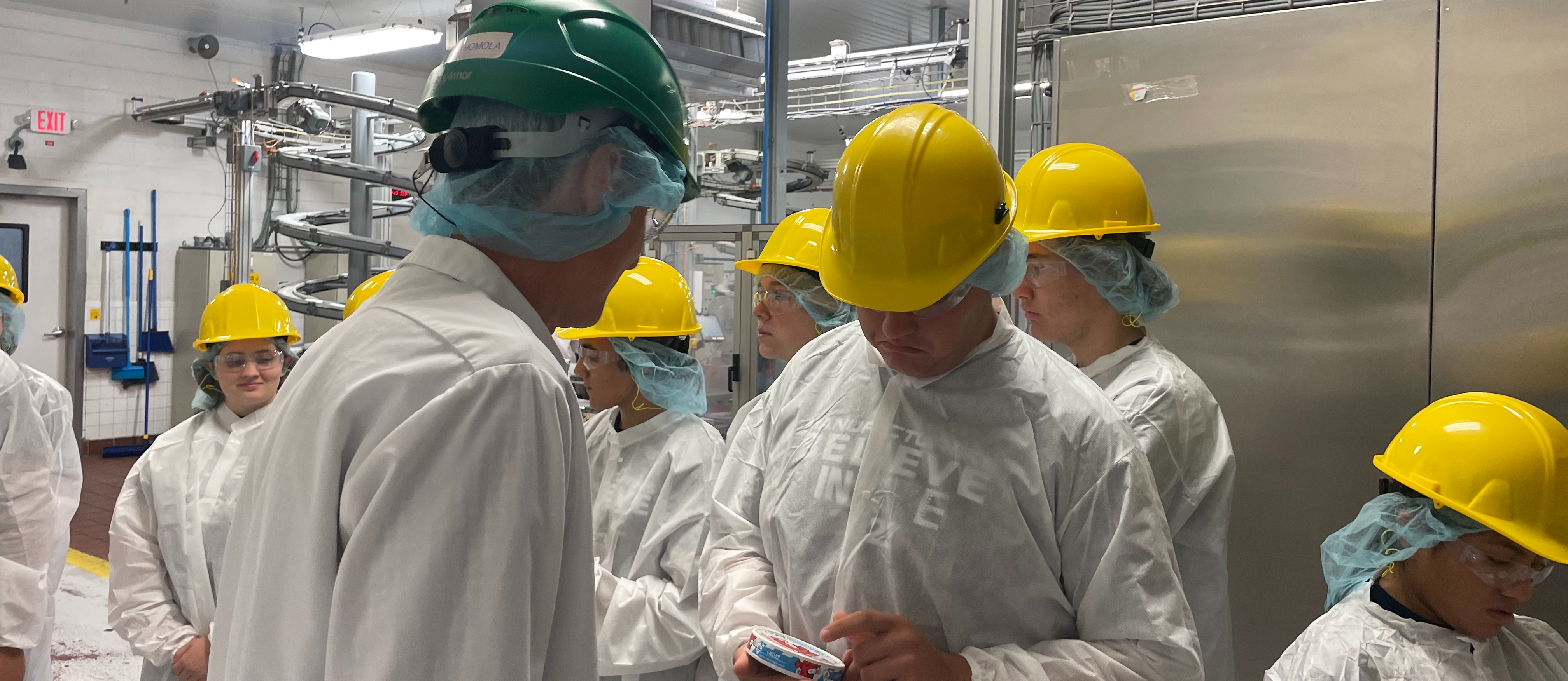 Students in hygenic apparel and hard hats tour Bel Brands