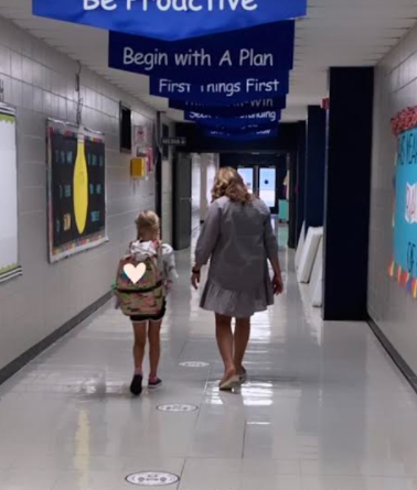 student walking down the hall with teacher