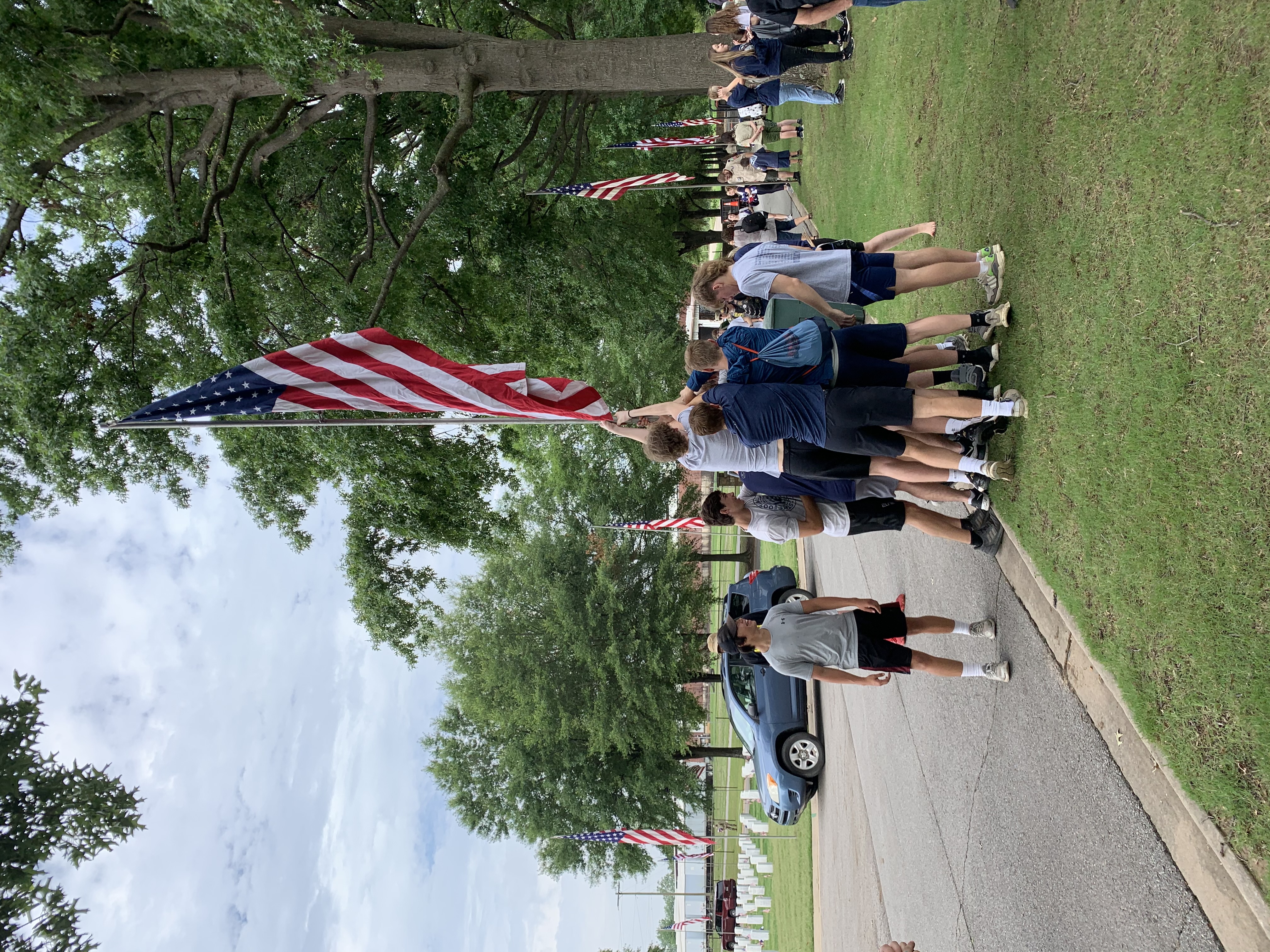 students raising the flag at the National Cemetary