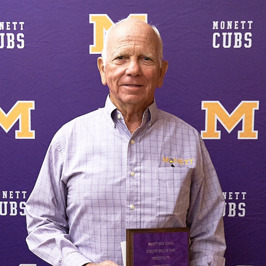 Male wearing a purple striped shirt with the M logo 