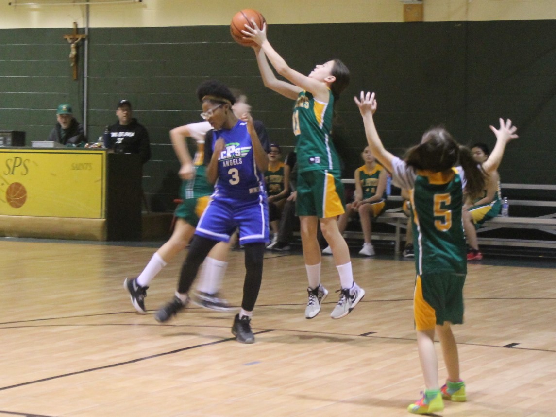 St. Peter School girls basketball team, competing against a team wearing purple