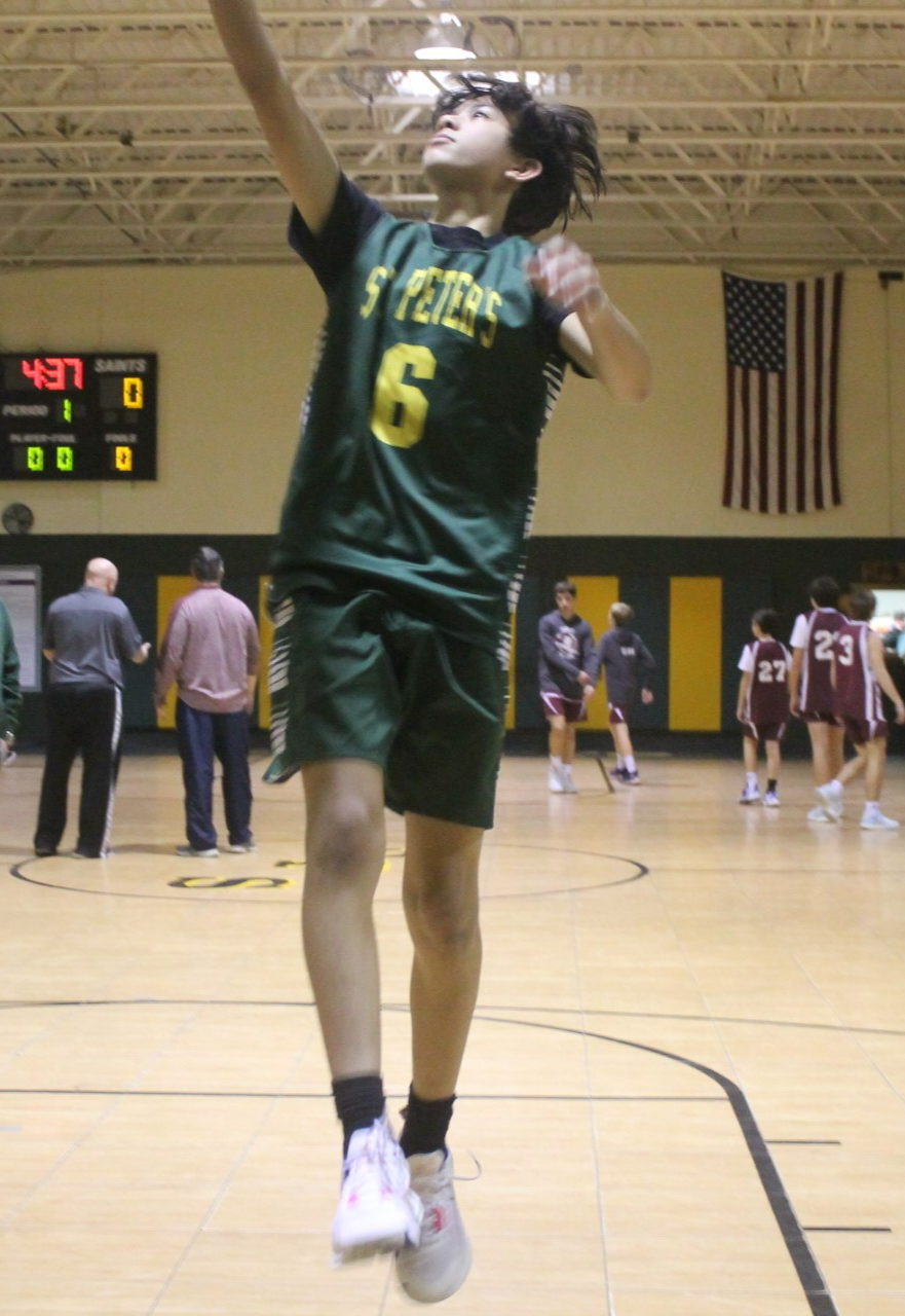 a St. Peter School student goes for a basketball layup