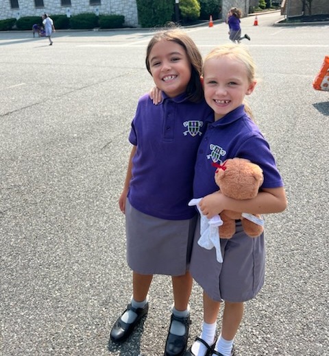 Two 3rd grade girls wearing  St. Peter School purple polo shirts.