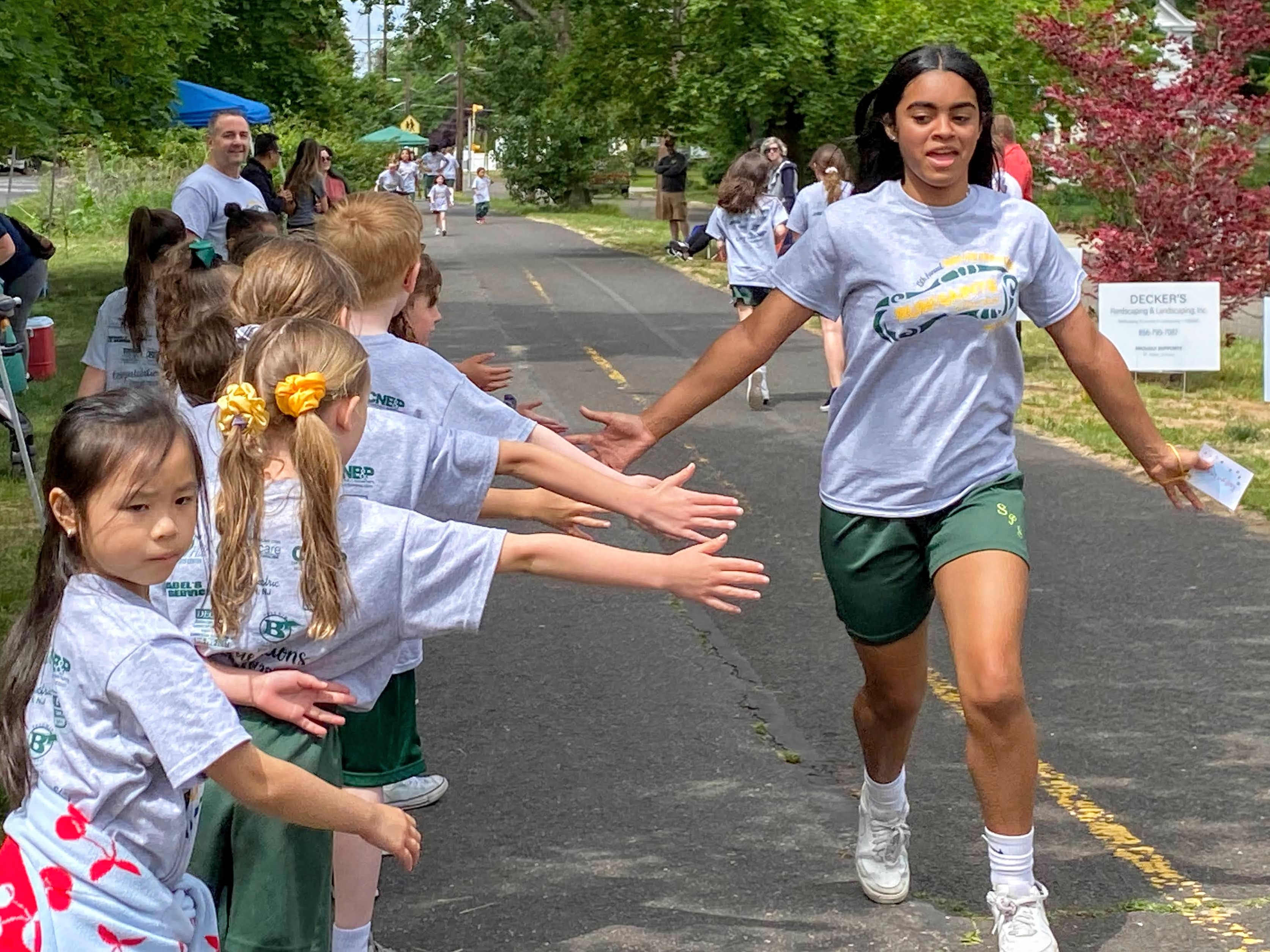 St. Peter School Students high fiving a runner in a line