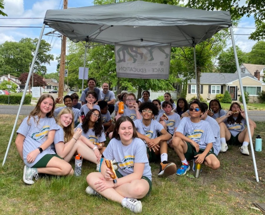 St. Peter School 7th grade students sitting under a canopy after their race