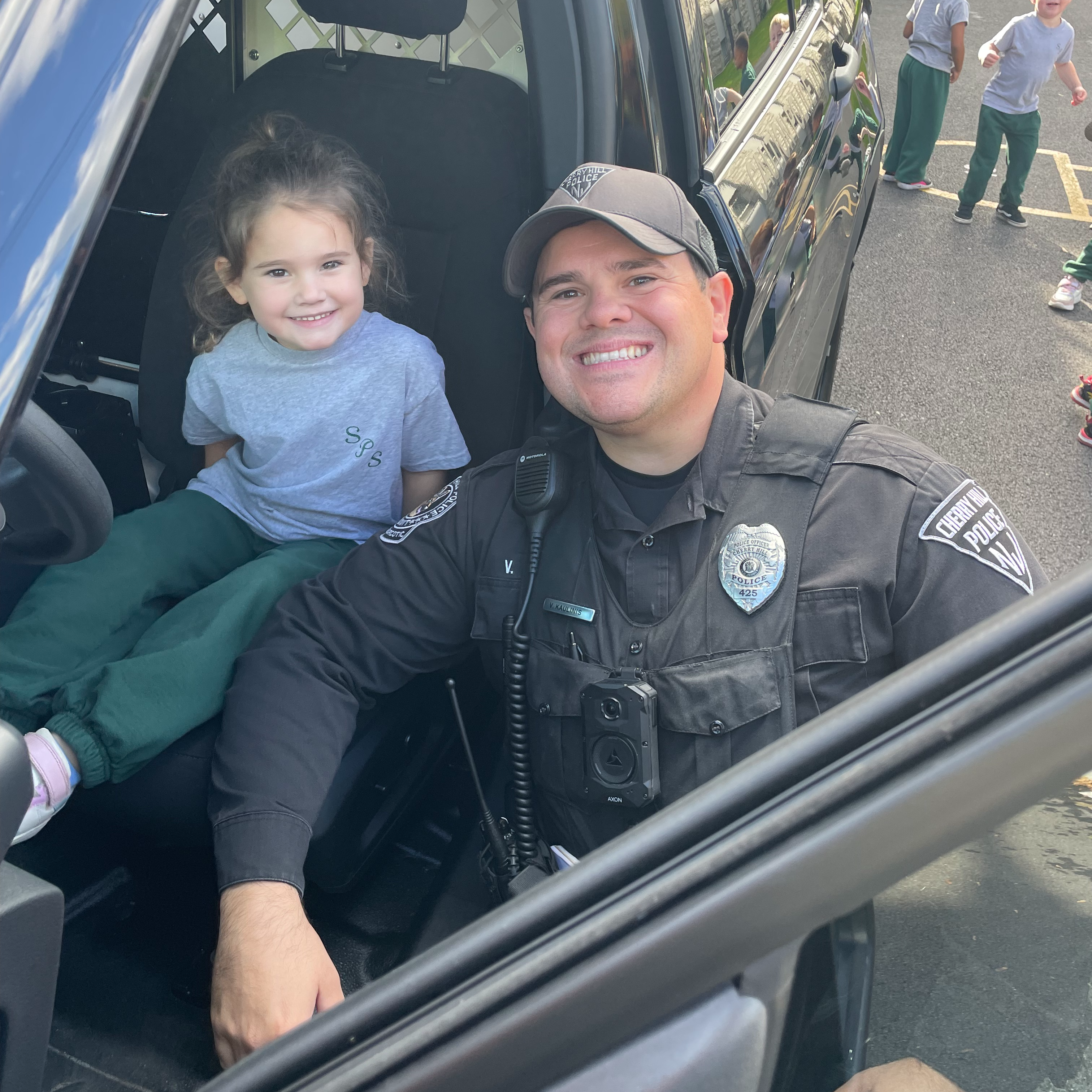 A preschool age girl with her father, a policeman
