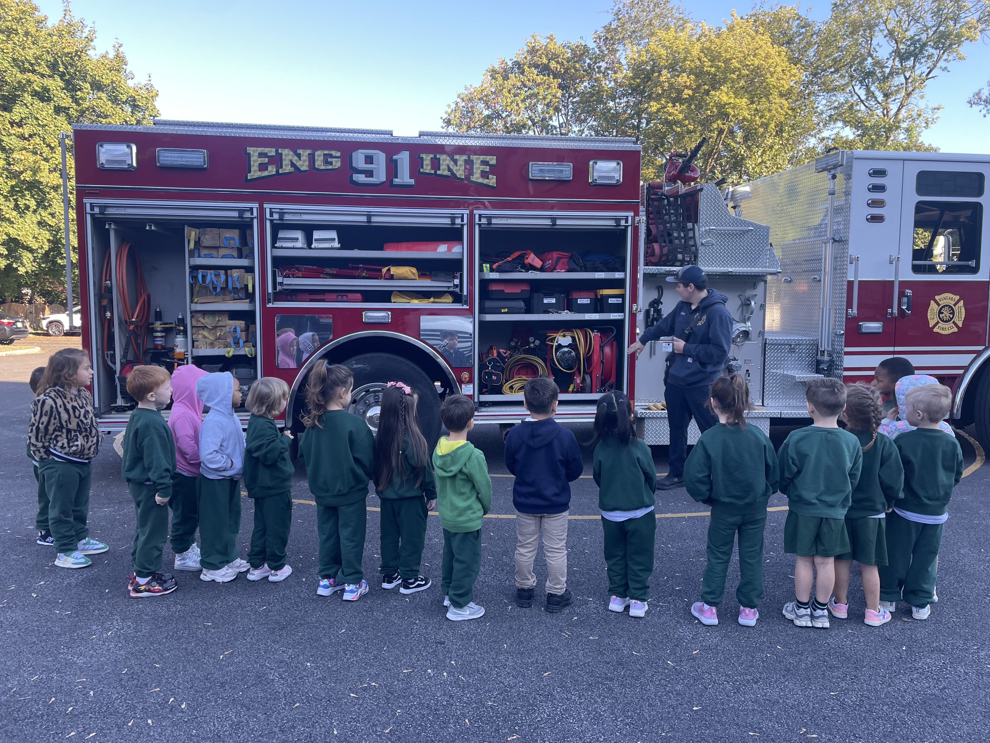 A group of pre-schoolers looking at a fire truck