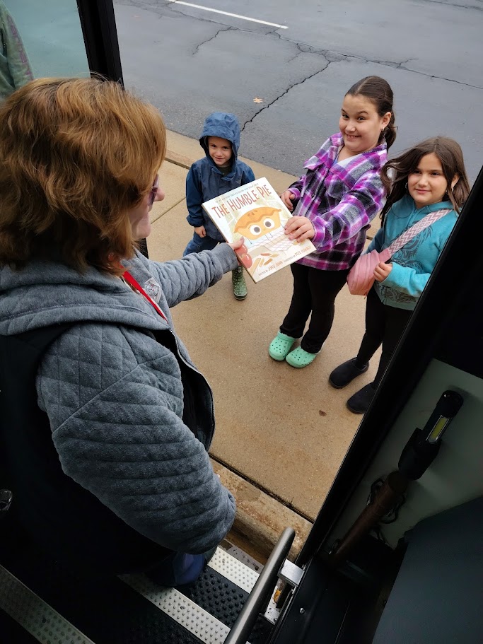 Angela collecting book from students