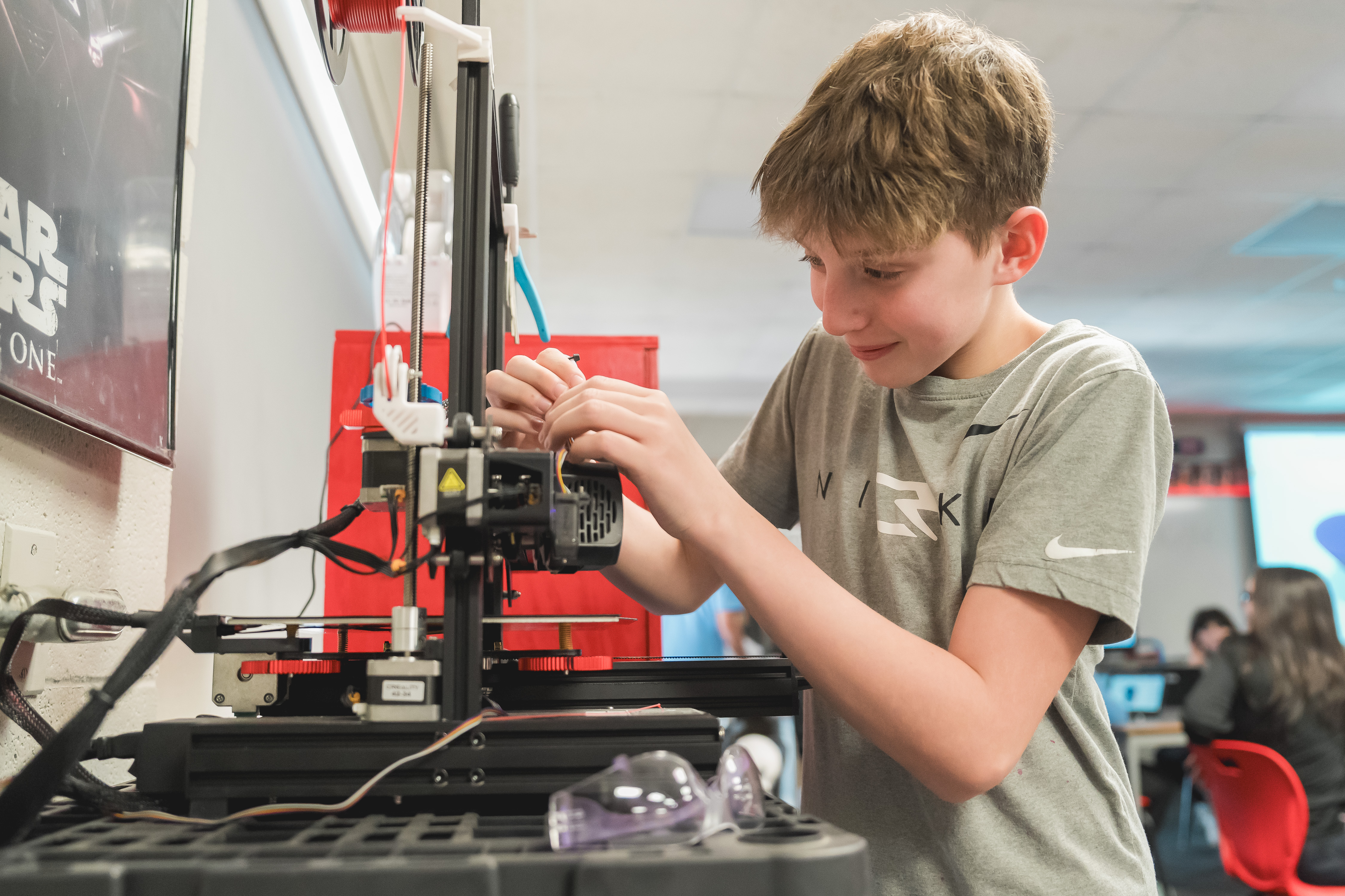 RC Middle school student working on 3D printer