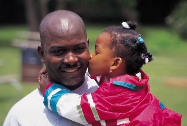 Photo of a girl kissing in the cheek to her dad.