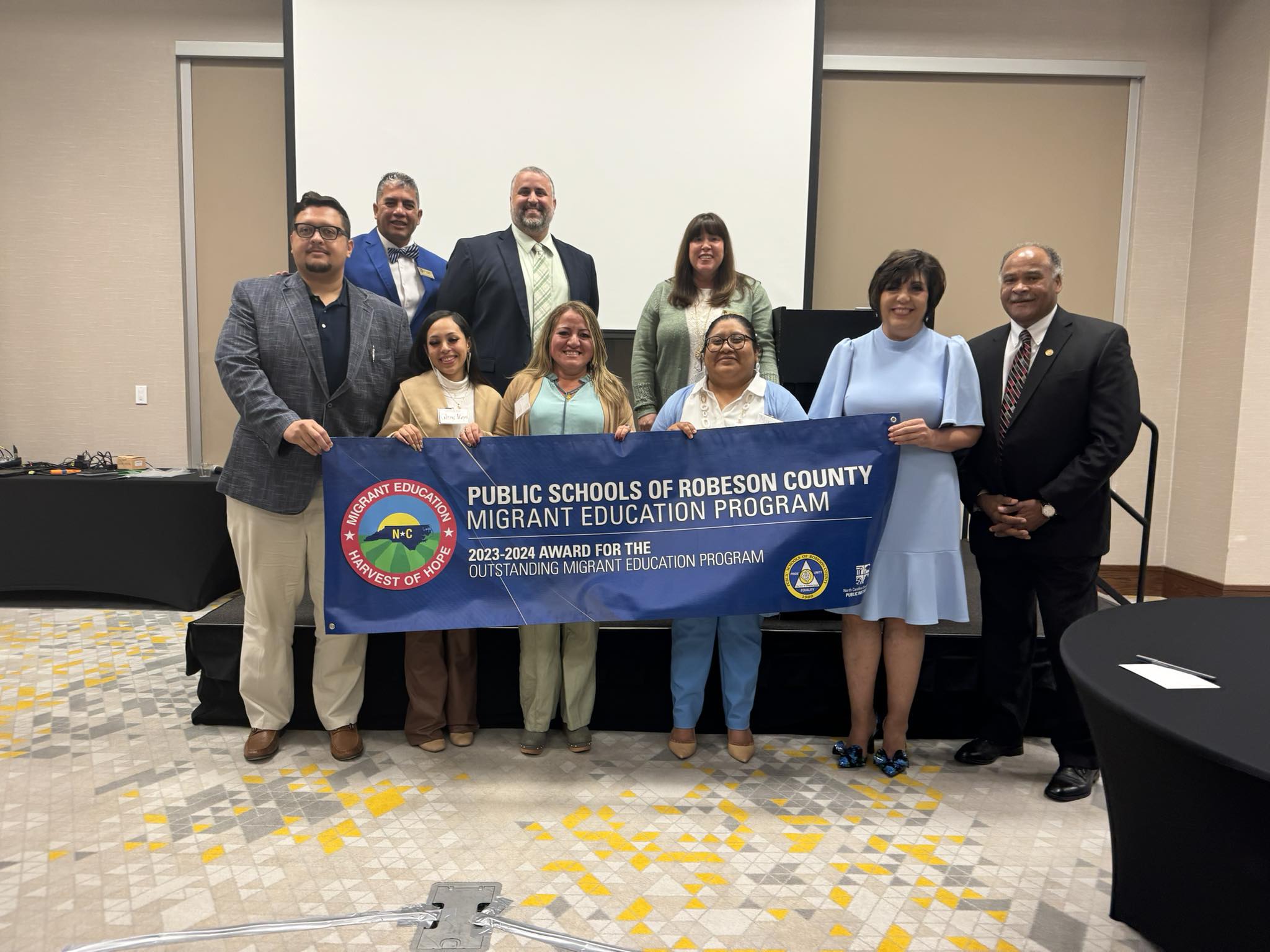 Migrant Education Staff recognized as best in state, staff holding banner