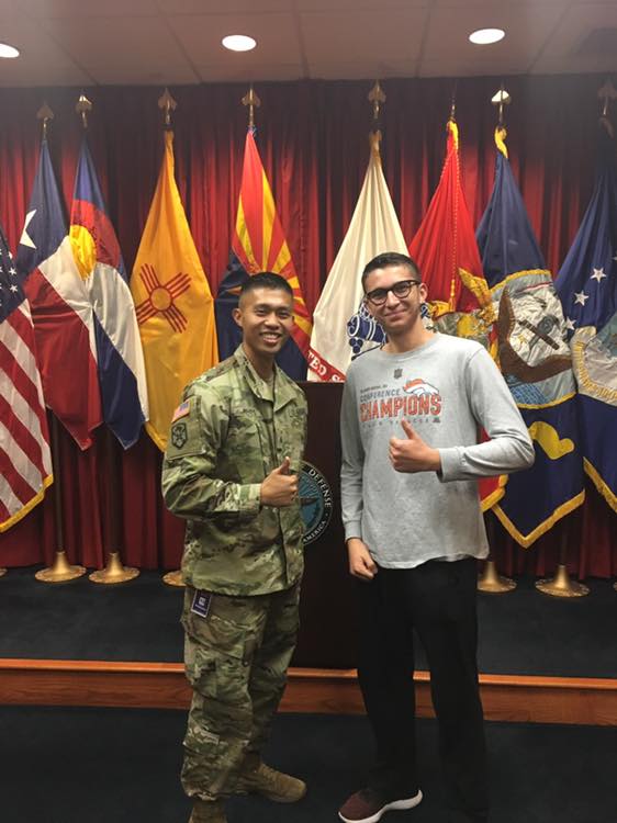 photo of two men in front of flags