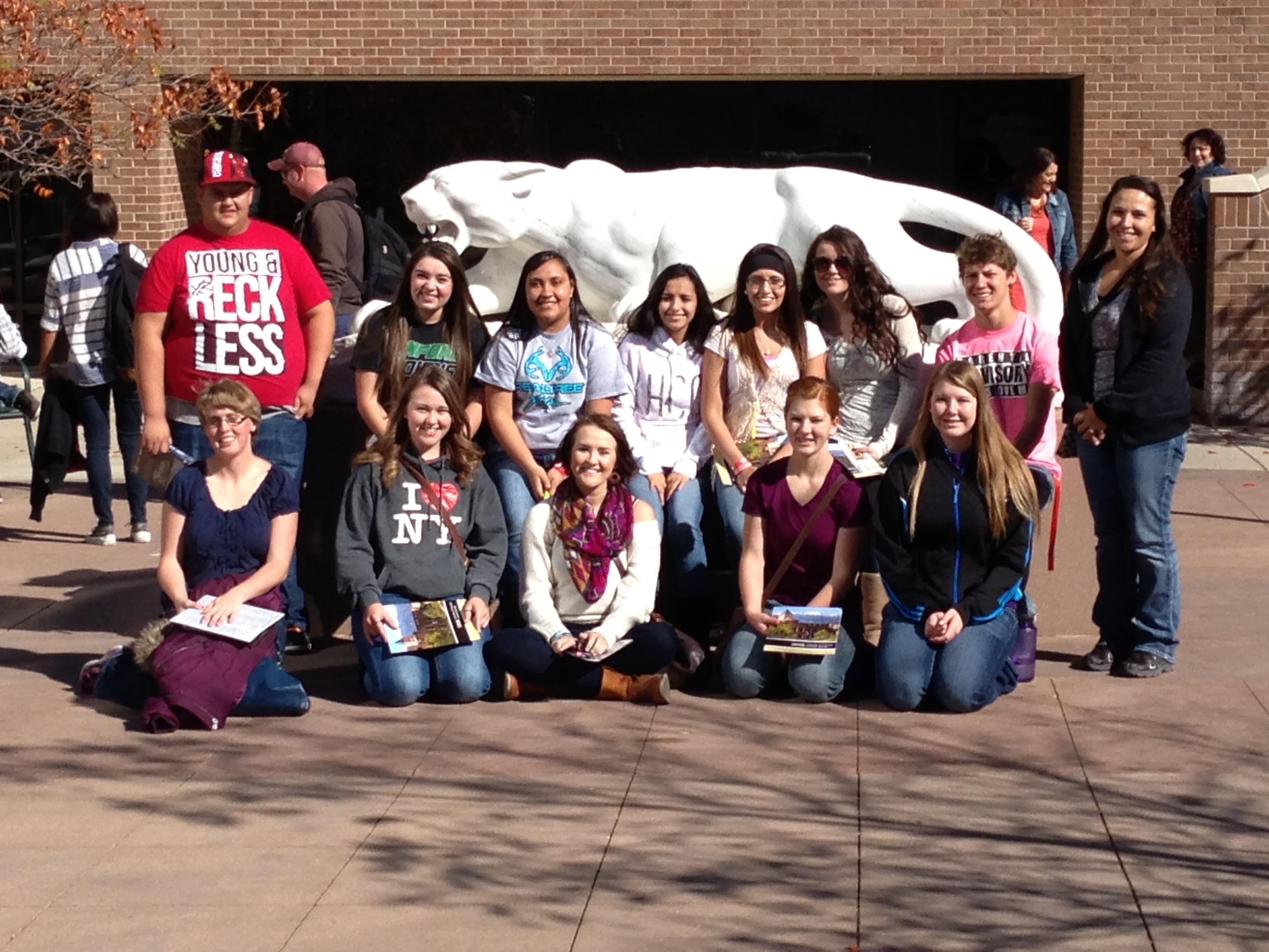 photo of a group of students in front of a statue of a mascot