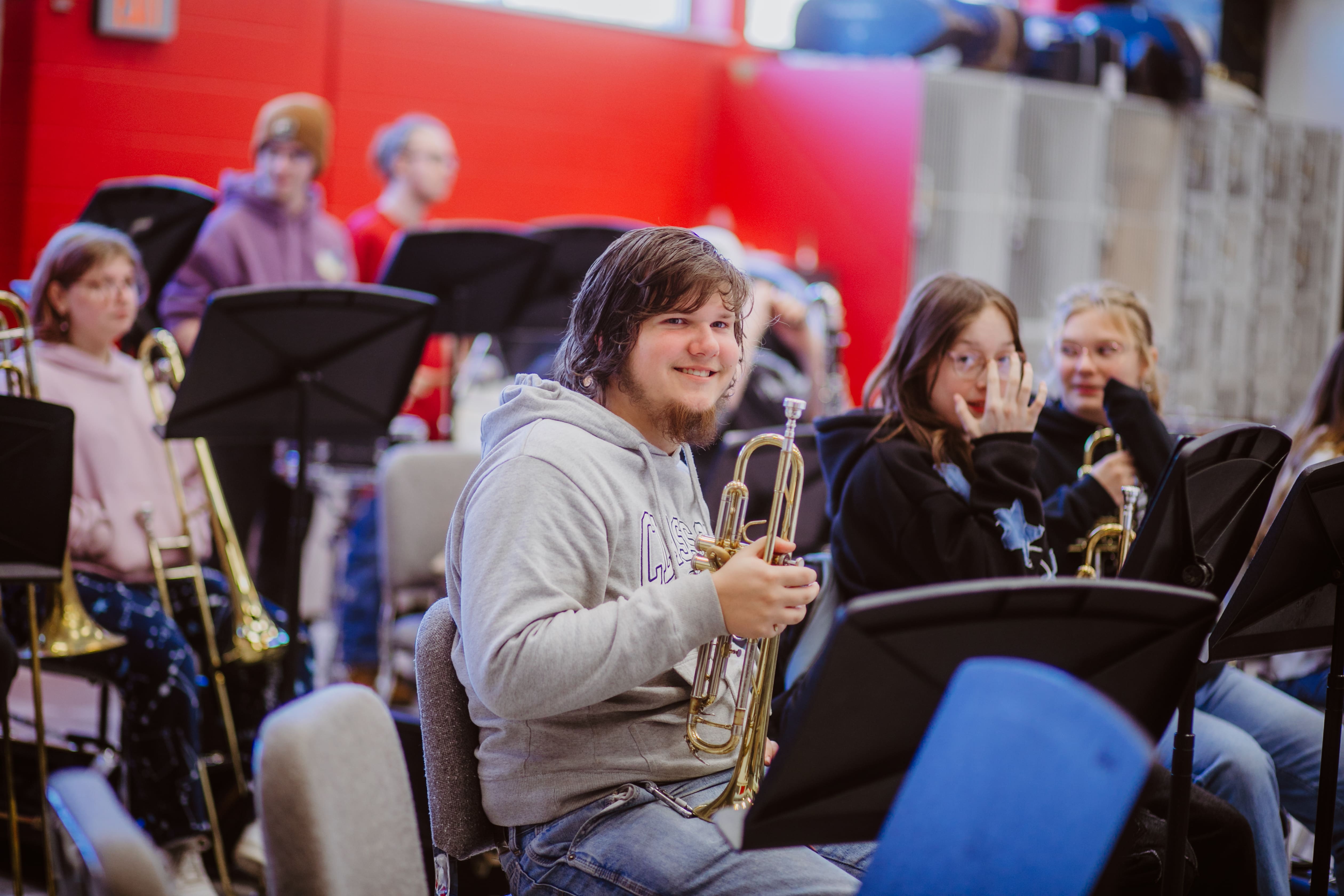 Smiling student with wind instrument 